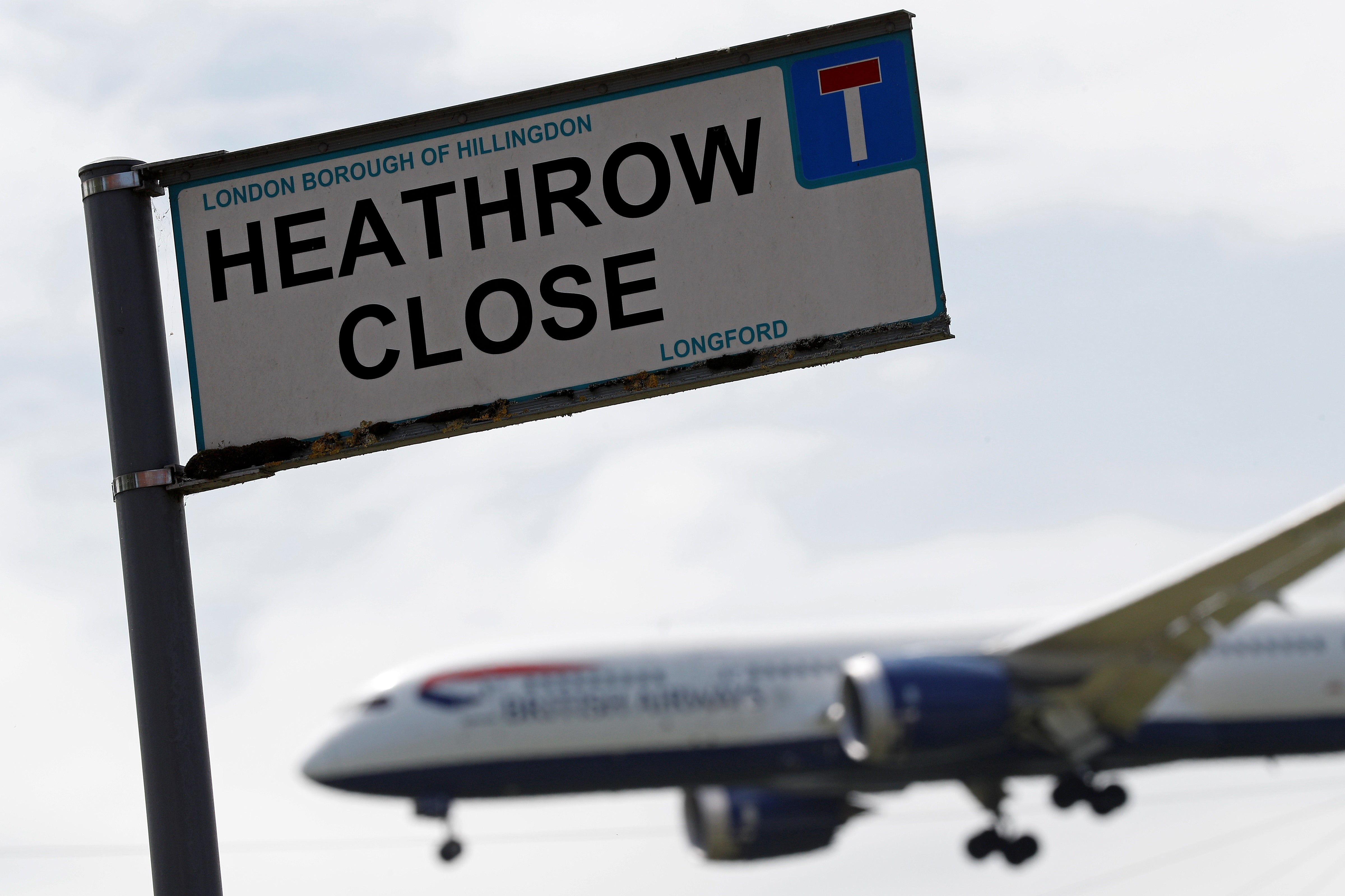 A British airways aircraft prepares to land at London Heathrow airport, beyond the village of Longford in west London