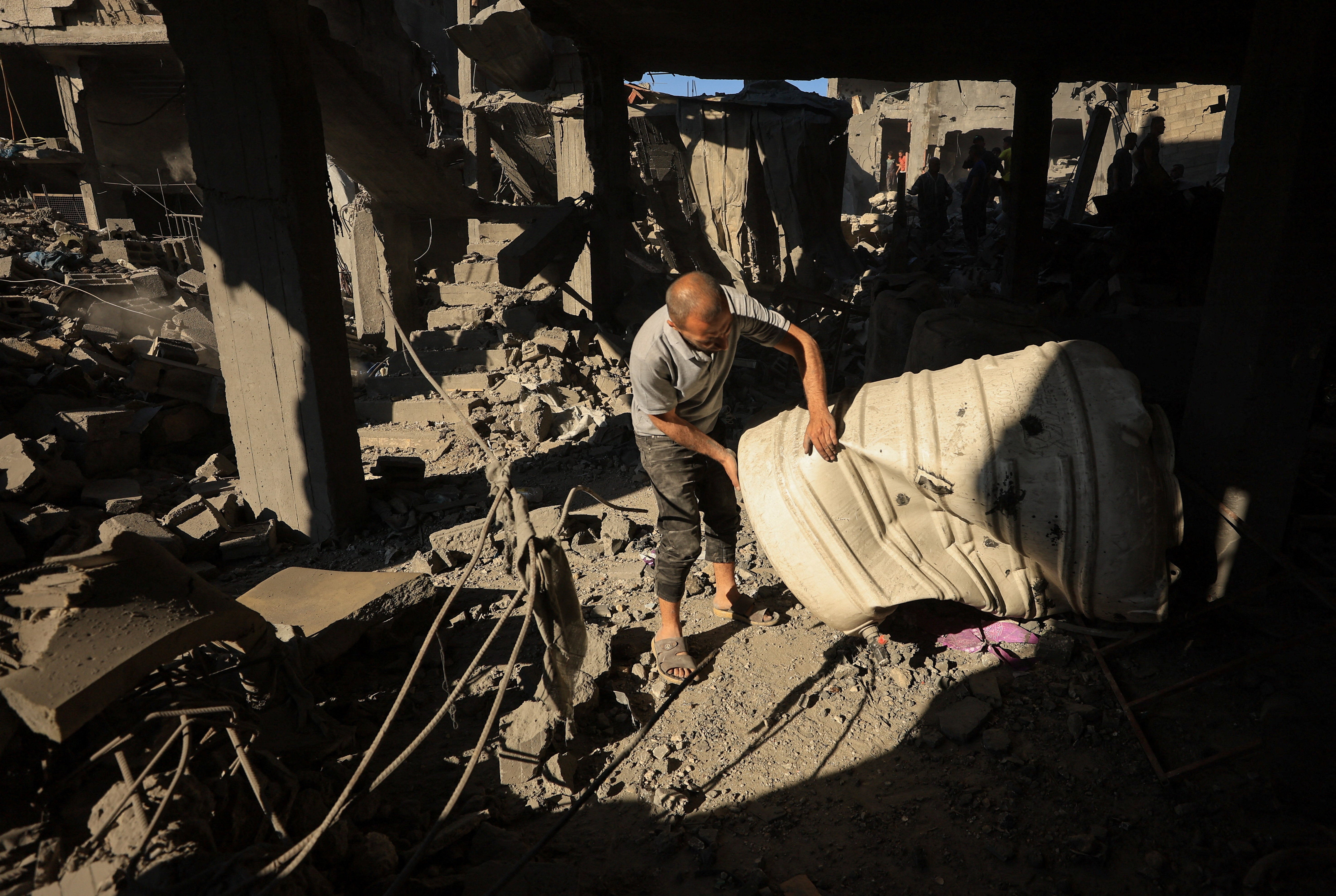 A Palestinian man works at the site of an Israeli strike on a house at Shati refugee camp in Gaza City, on Friday (Reuters)