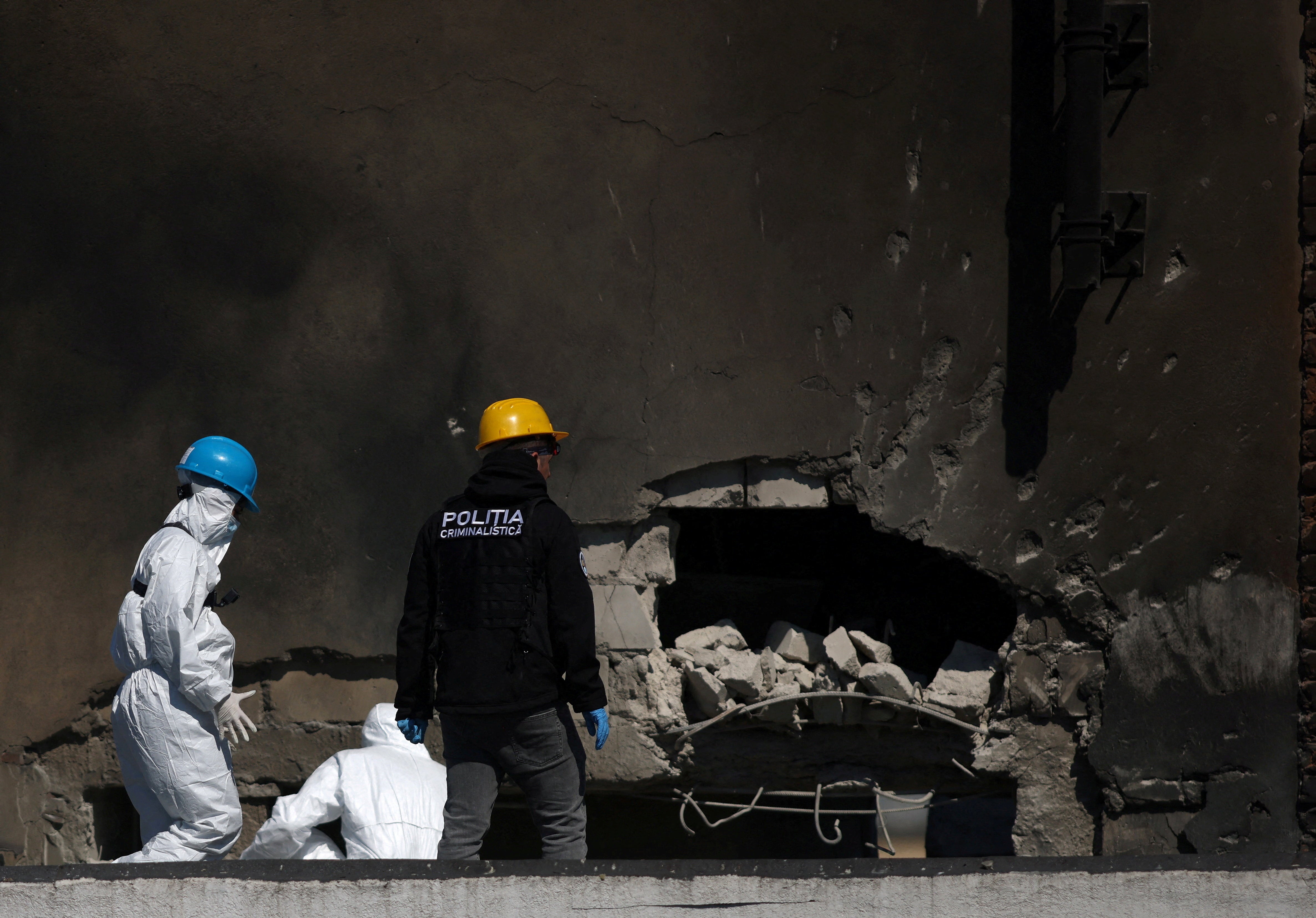 Romanian law enforcement officers work on the site of the explosion (Reuters)