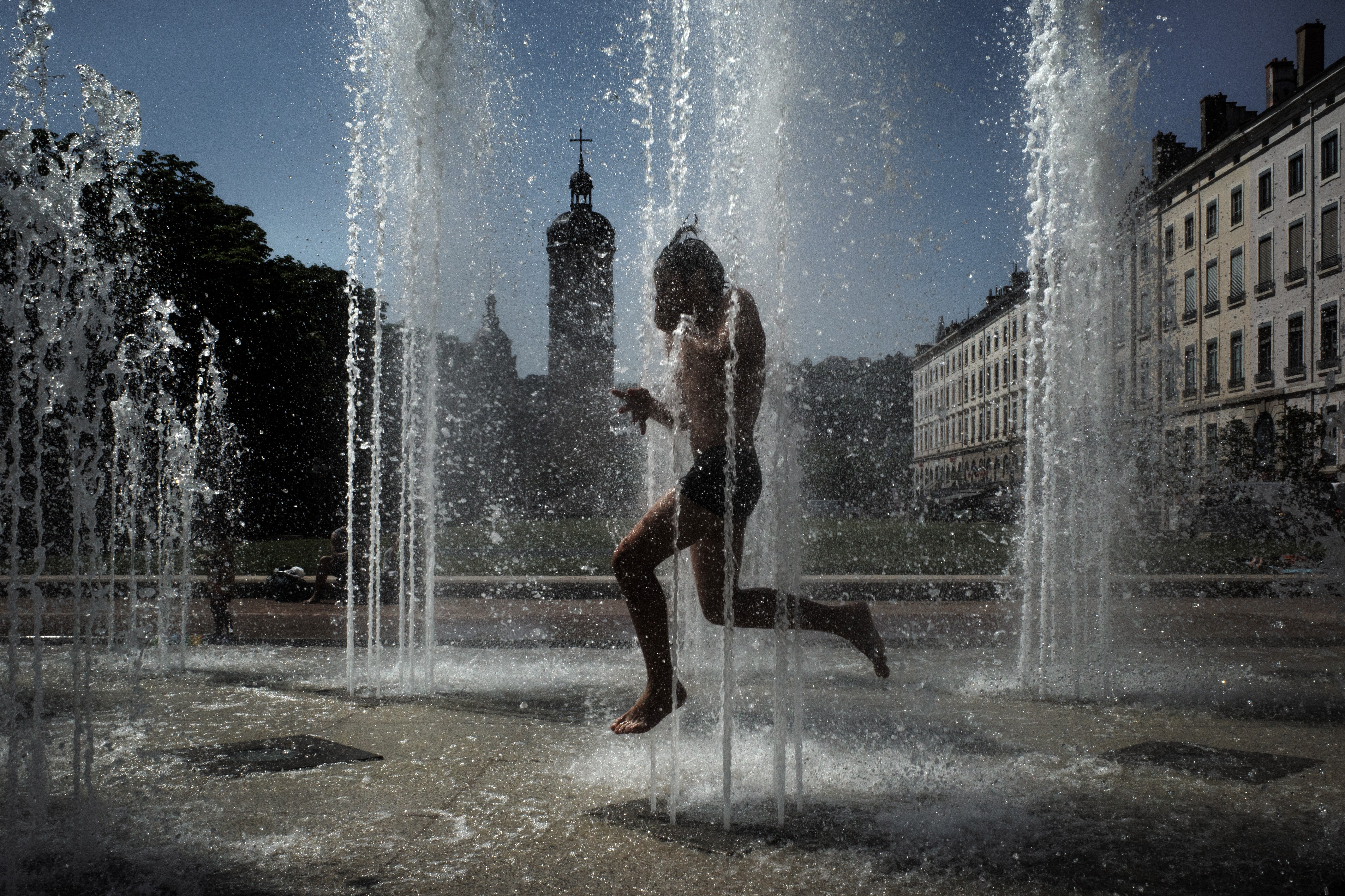 A child cools off in a fountain in Lyon on May 27, 2026 as a heatwave hits France