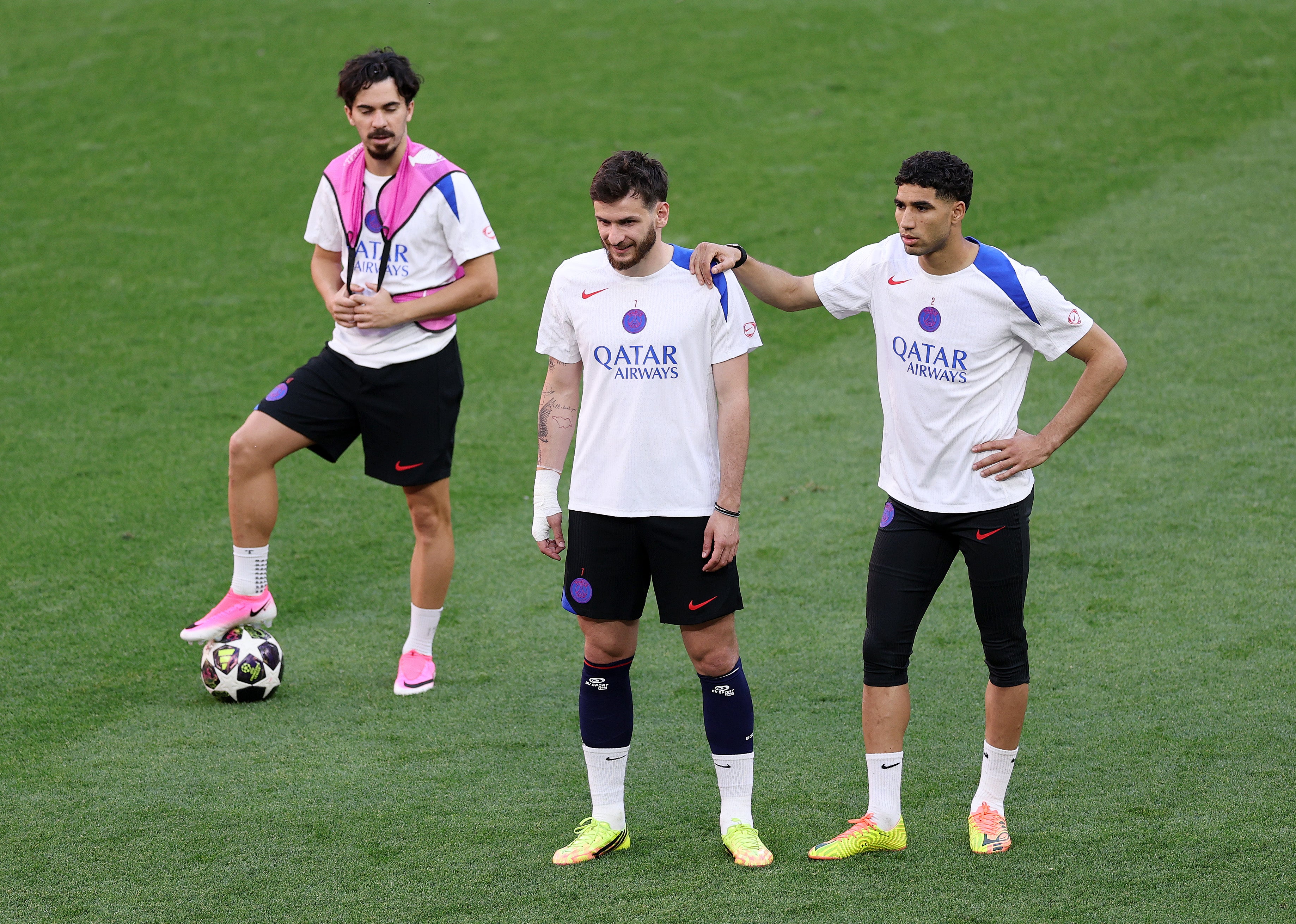 Vitinha, Khvicha Kvaratskhelia and Achraf Hakimi of Paris Saint-Germain look on during the training session