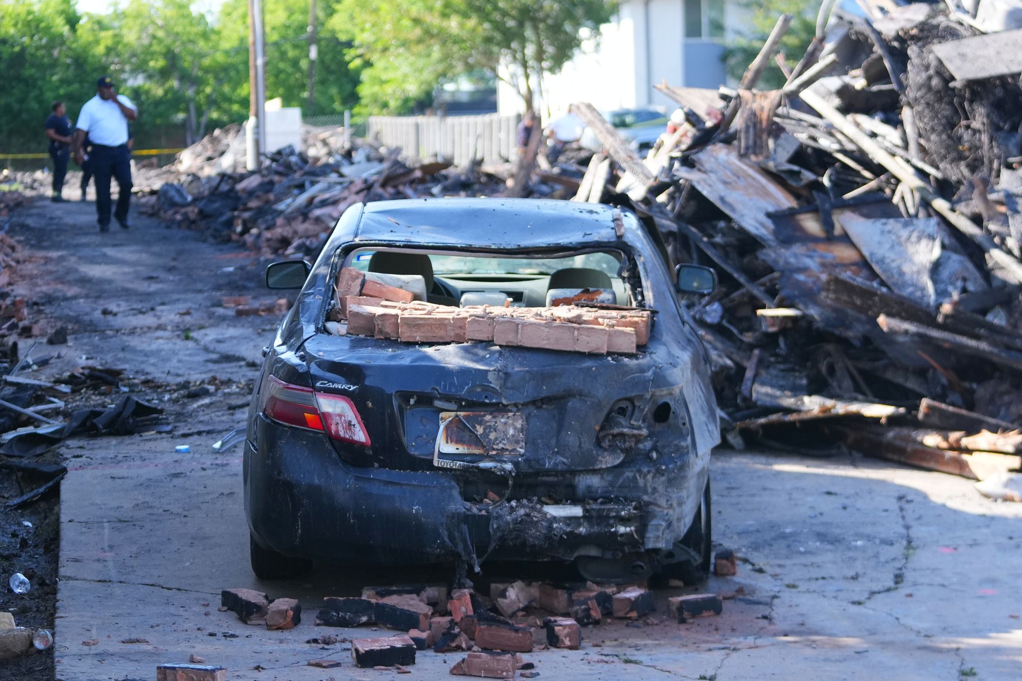 A vehicle is seen damaged following the explosion and fire at the apartment complex (AP Photo/Julio Cortez)
