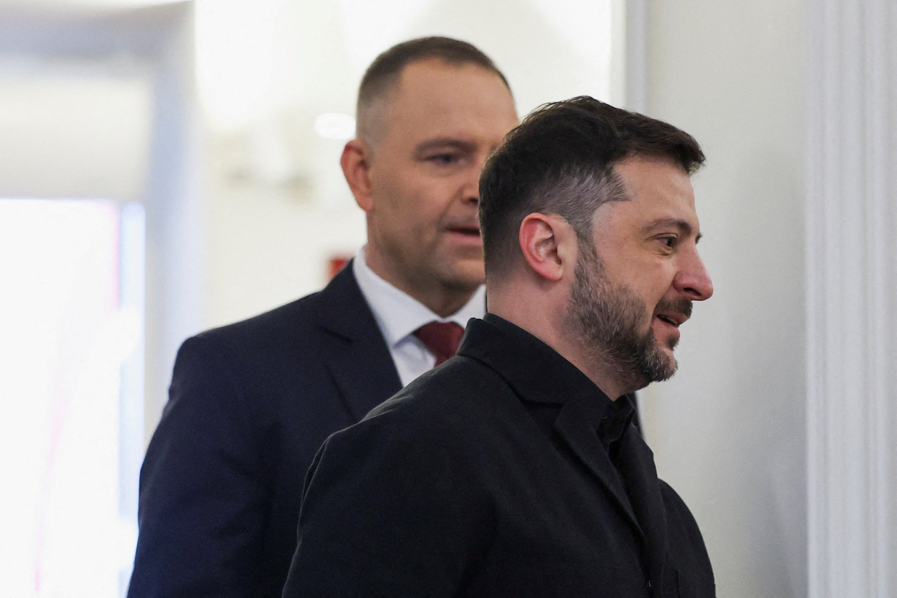 Ukrainian President Volodymyr Zelenskiy walks with Polish President Karol Nawrocki as they meet at the Presidential Palace in Warsaw in December 2025