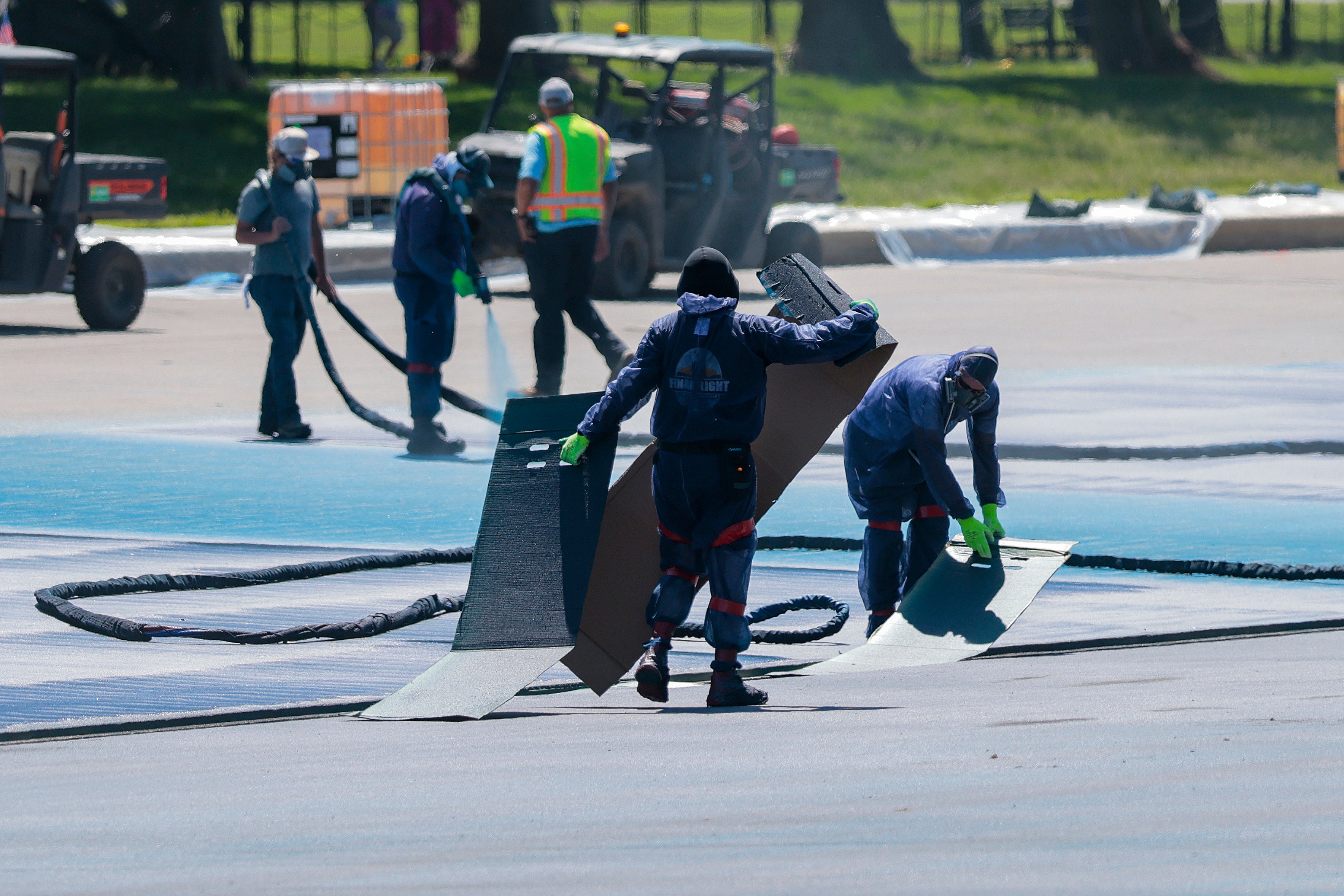 Workers paint a blue coating on the Lincoln Memorial reflecting pool
