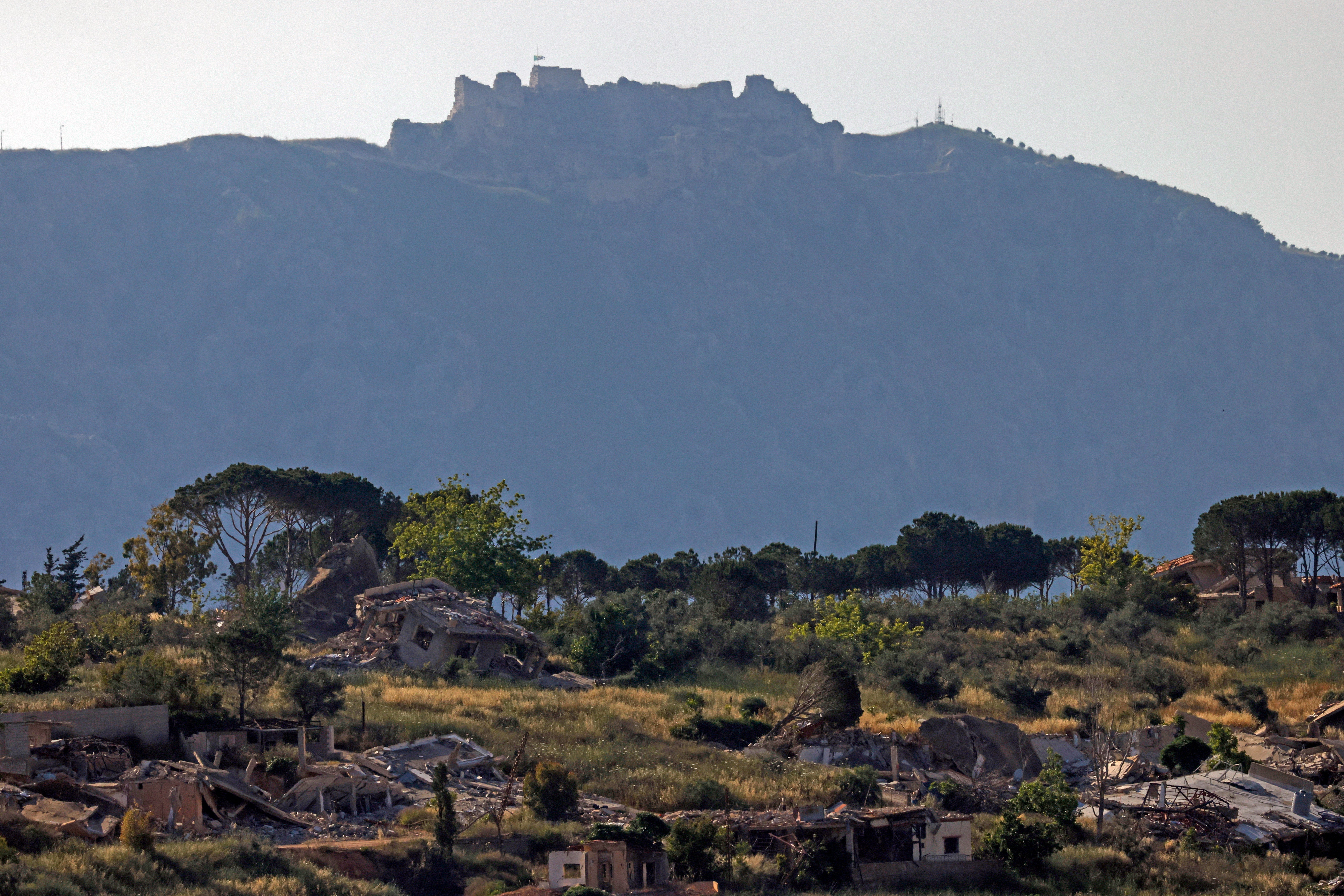This picture taken from a position in the Upper Galilee region in northern Israel shows destroyed buildings in the southern Lebanon against the backdrop of the medieval Beaufort Castle, locally known as Qalaat al-Shaqif or Shaqif Arnoun, on May 31, 2026. Israeli Prime Minister Benjamin Netanyahu vowed to push deeper into Lebanon after his military took over the medieval castle of Beaufort on May 31, calling it a 