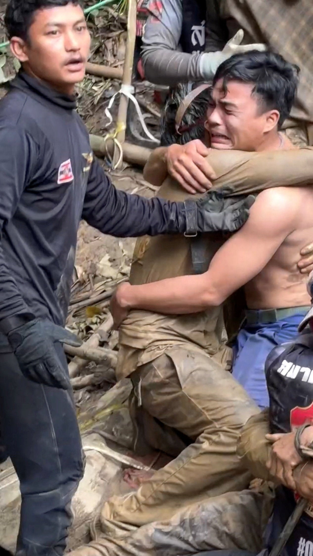 A rescued man is embraced, after seven Lao nationals who had entered a cave to prospect for gold were trapped for more than a week when rising water blocked their exit, in Xaisomboun province, Laos, 30 May 2026, in this screen grab taken from social media video