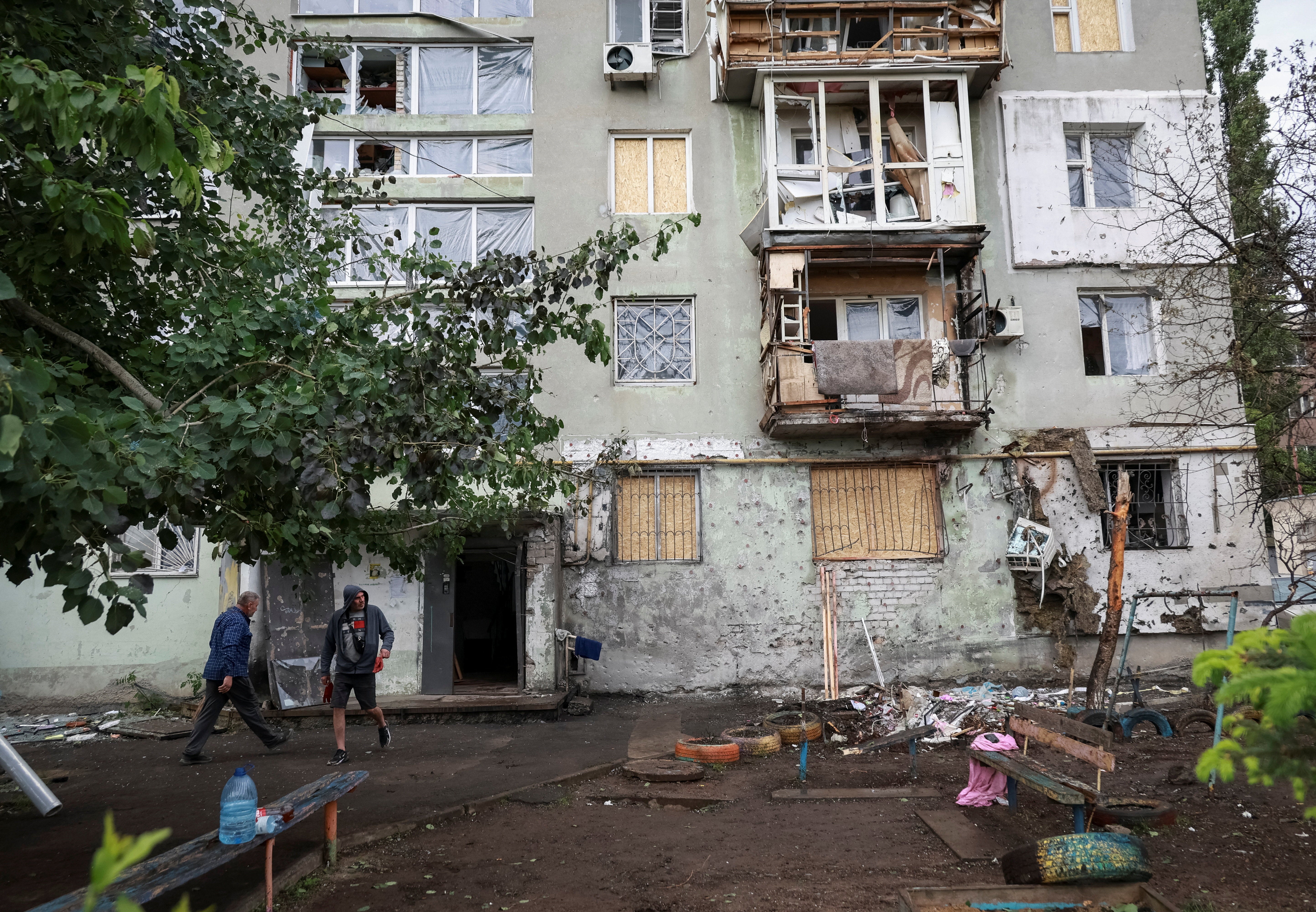Residents walk near the apartment building damaged by a Russian drone strike in Odesa, June 1 (Reuters)