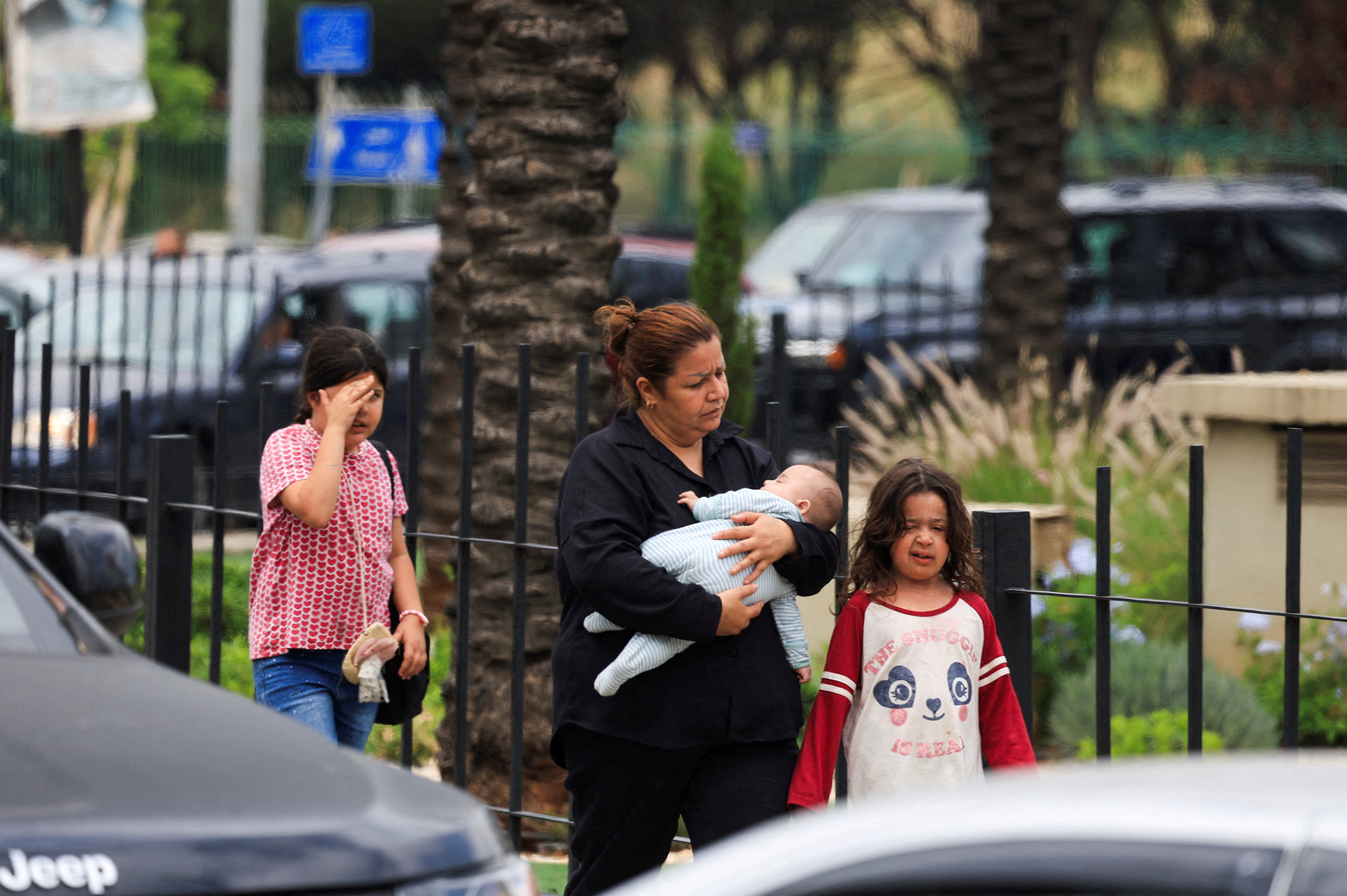 A woman carrying a child walks along a road as people flee the southern suburbs of Beirut, after Israeli Prime Minister Benjamin Netanyahu ordered the military to attack targets in the suburbs, Lebanon, June 1, 2026. (Reuters)