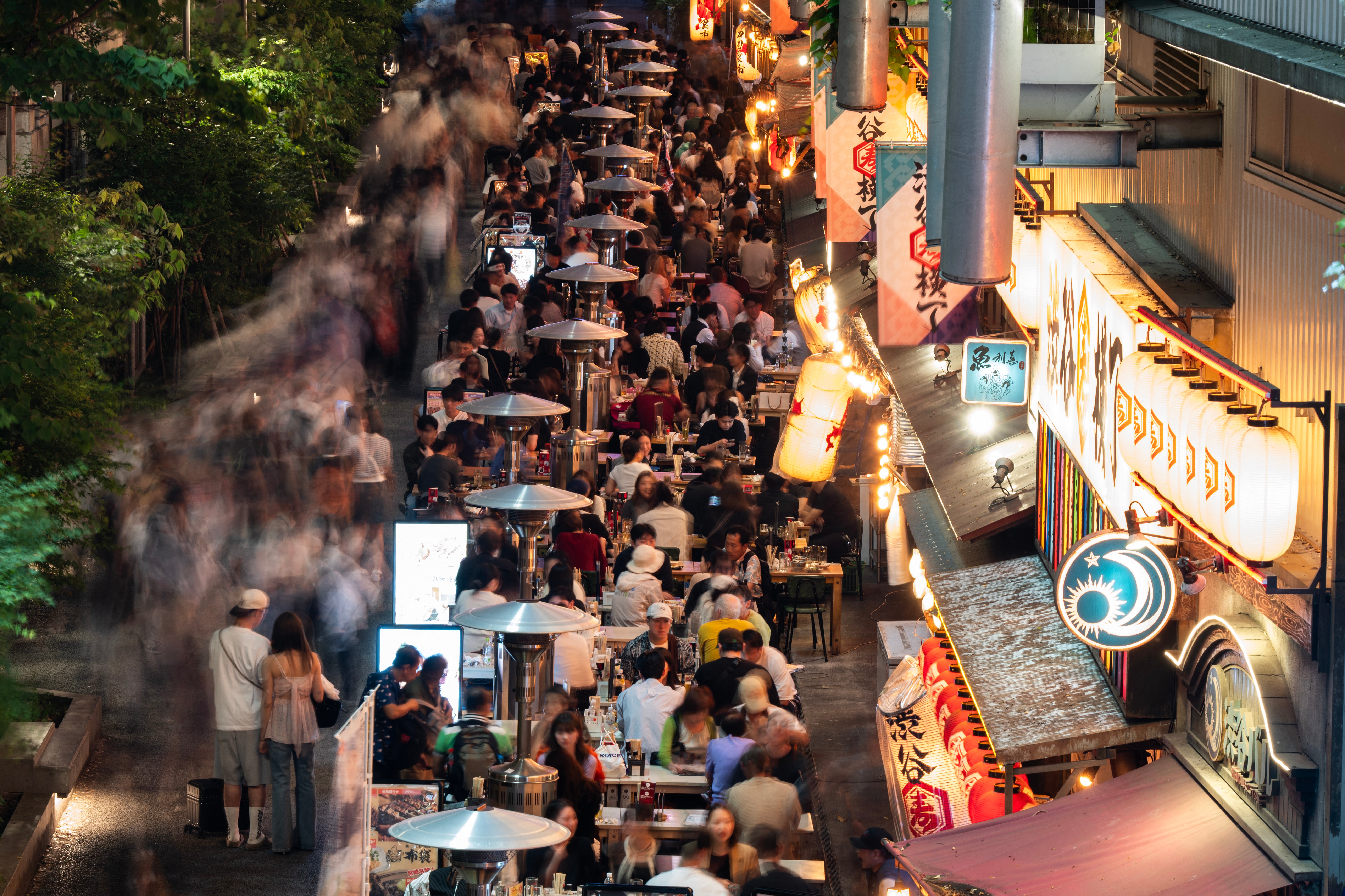 People eat at restaurants in an area frequented by tourists in Tokyo's Shibuya