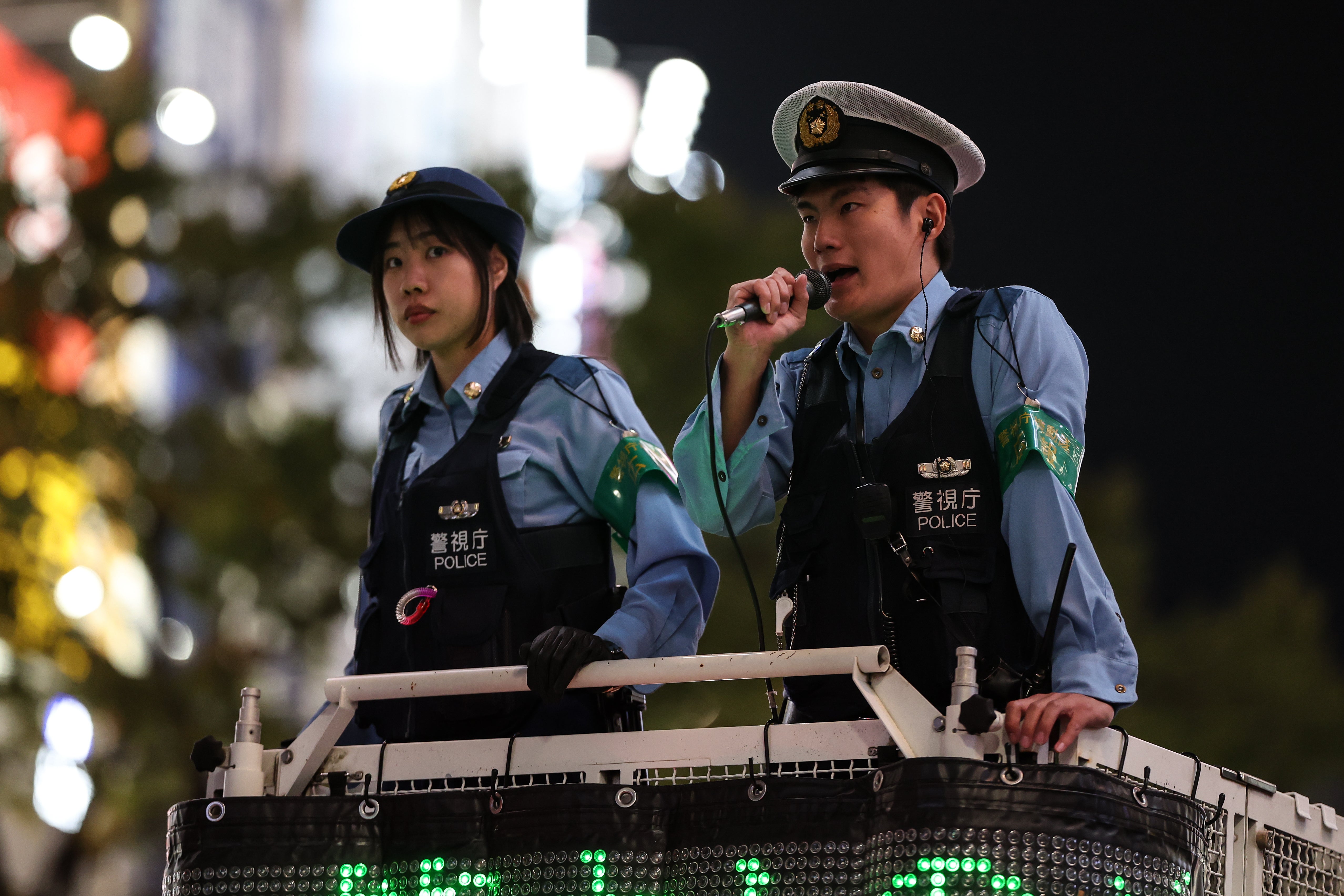 Police officers speak to pedestrians at the Shibuya Crossing in Tokyo