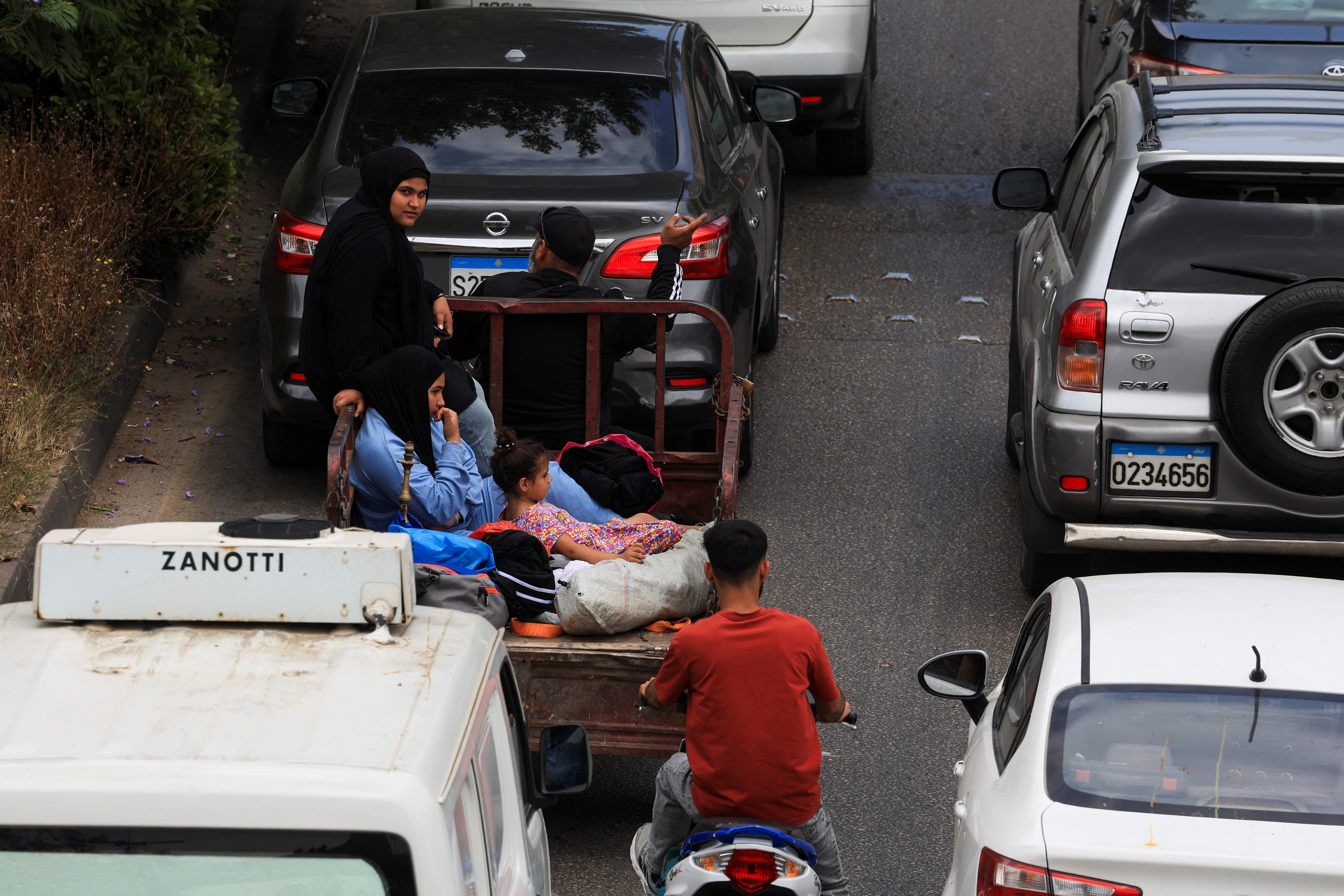 A woman and children sit behind a motorized vehicle as people make their way while fleeing the southern suburbs of Beirut, after Israeli Prime Minister Benjamin Netanyahu ordered the military to attack targets in the suburbs, Lebanon, June 1, 2026. (Reuters)