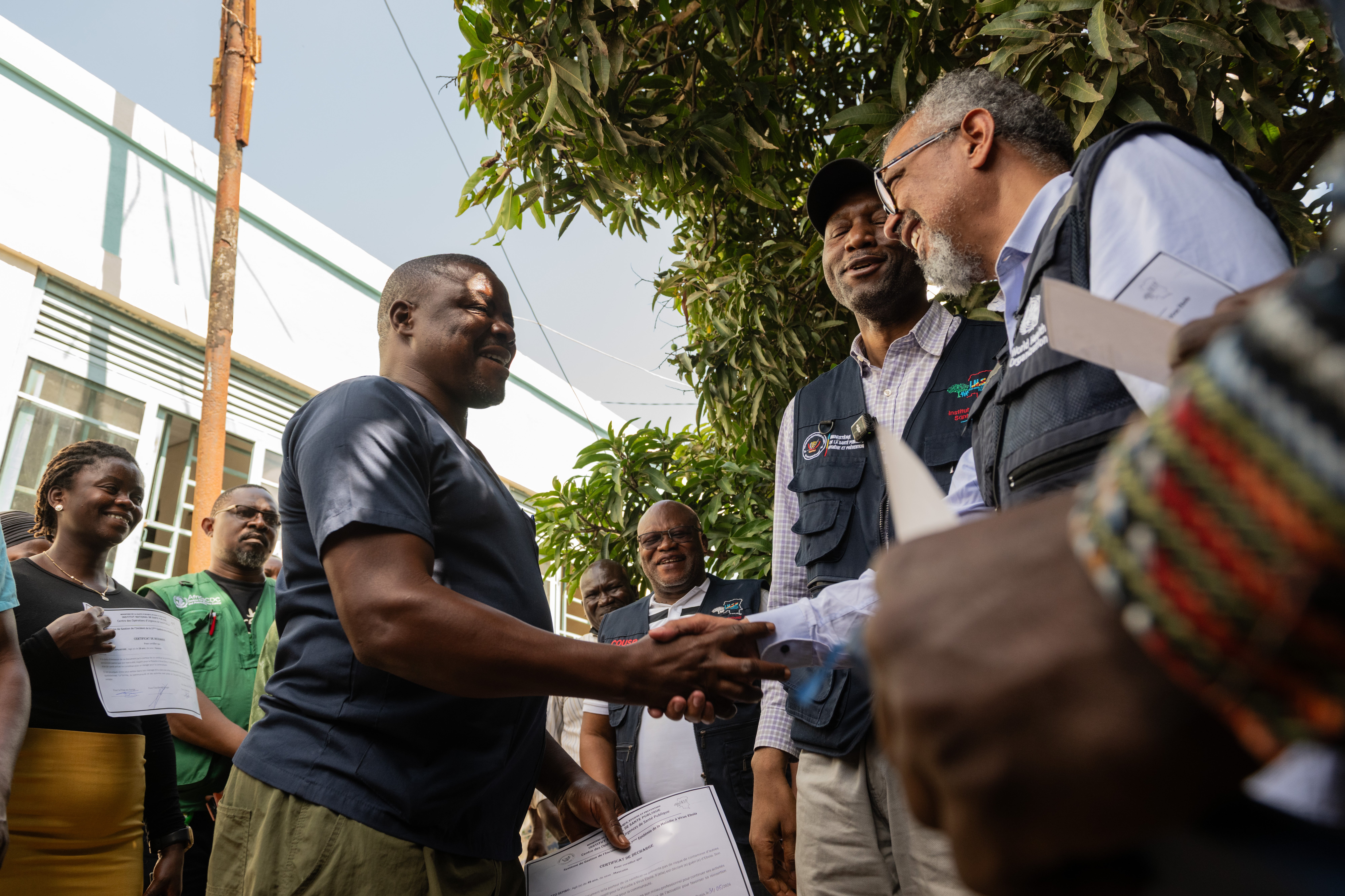 Director General of the World Health Organization (WHO), Tedros Adhanom Ghebreyesus, right, shakes hands with Ezo Étienne