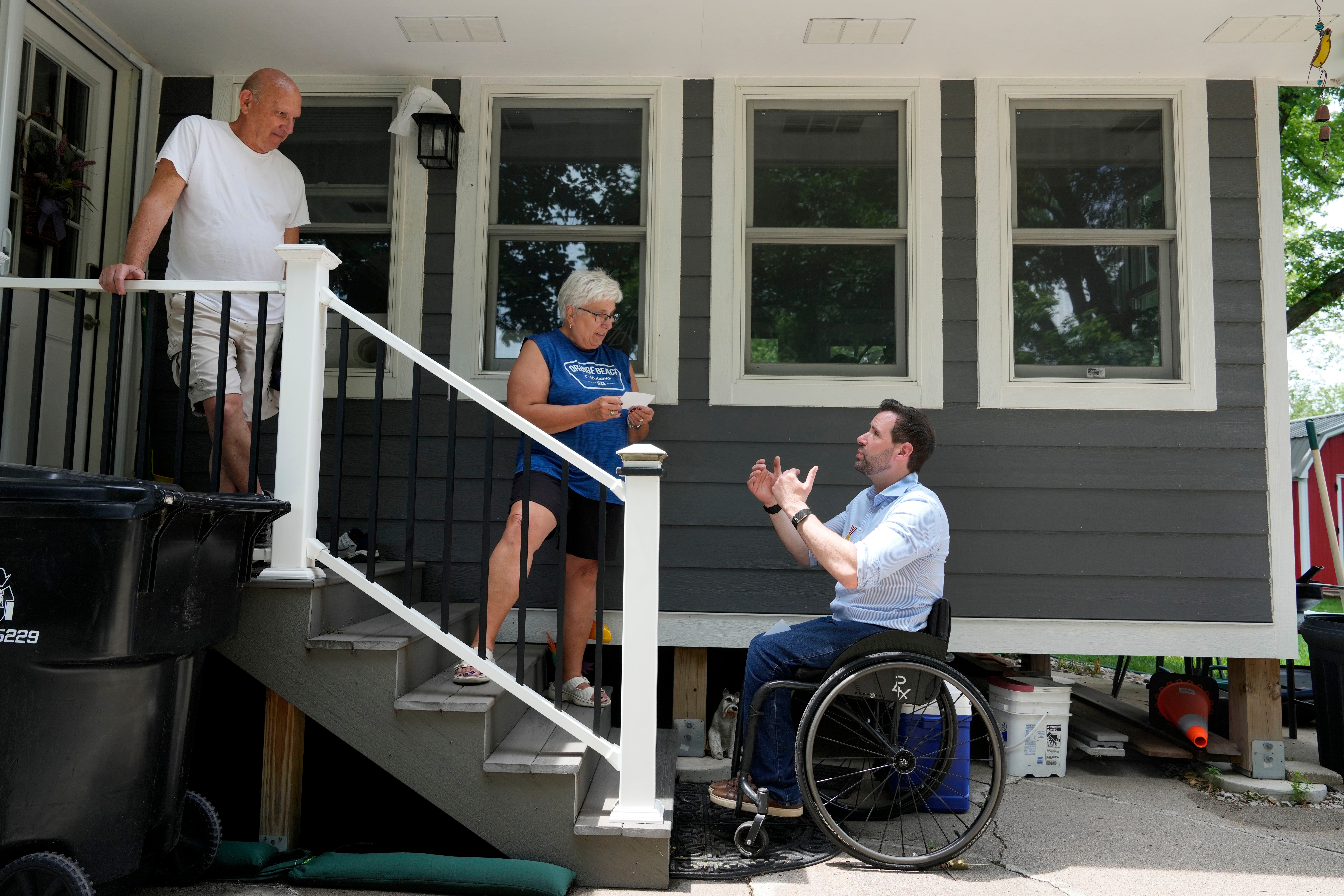 Iowa state Rep. Josh Turek, a Democratic candidate for U.S. Senate, talks with John, left, and Jane Walker outside their home while canvassing, Sunday, May 31, 2026, in Waukee, Iowa. (AP Photo/Charlie Neibergall) (AP)