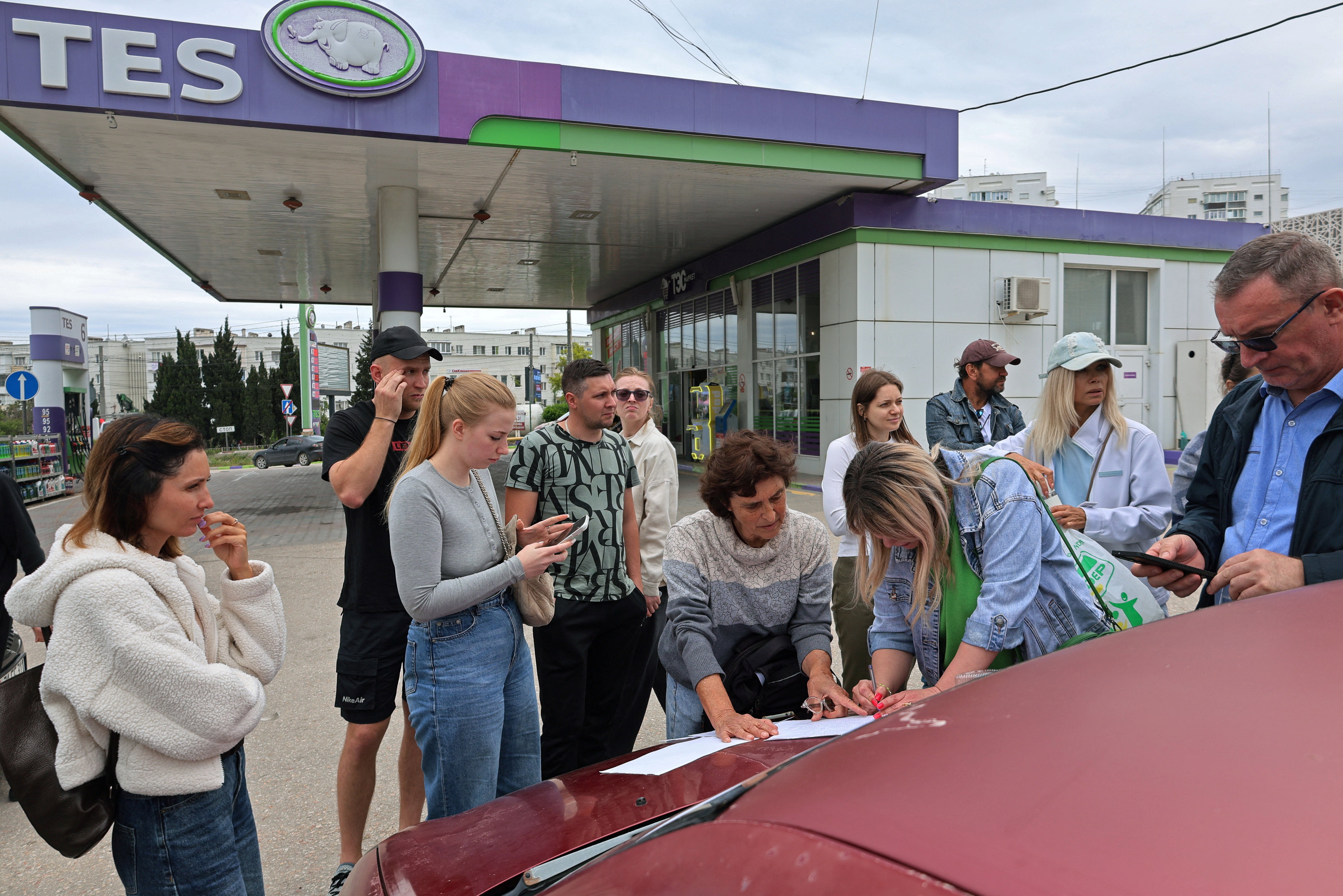 People put their names on a list to join the queue for fuel at a gas station after the authorities restricted fuel sales in Sevastopol, Crimea