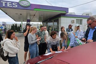 People put their names on a list to join the queue for fuel at a gas station after the authorities restricted fuel sales in Sevastopol, Crimea