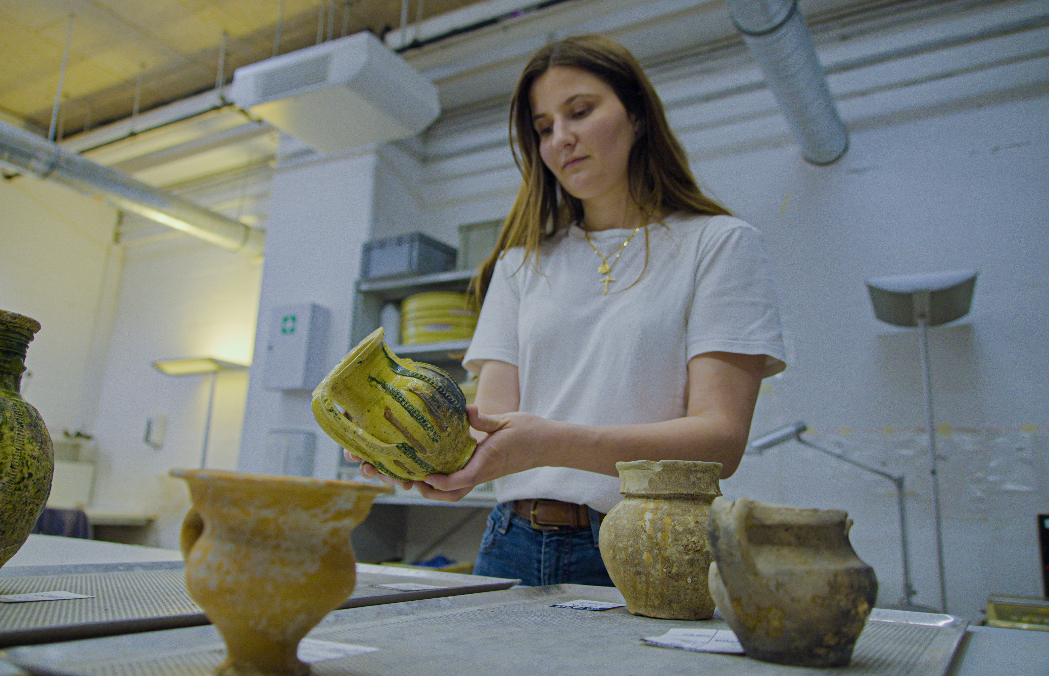 Archaeologist Valentine Breloux, holds ceramic fragments discovered during the excavations