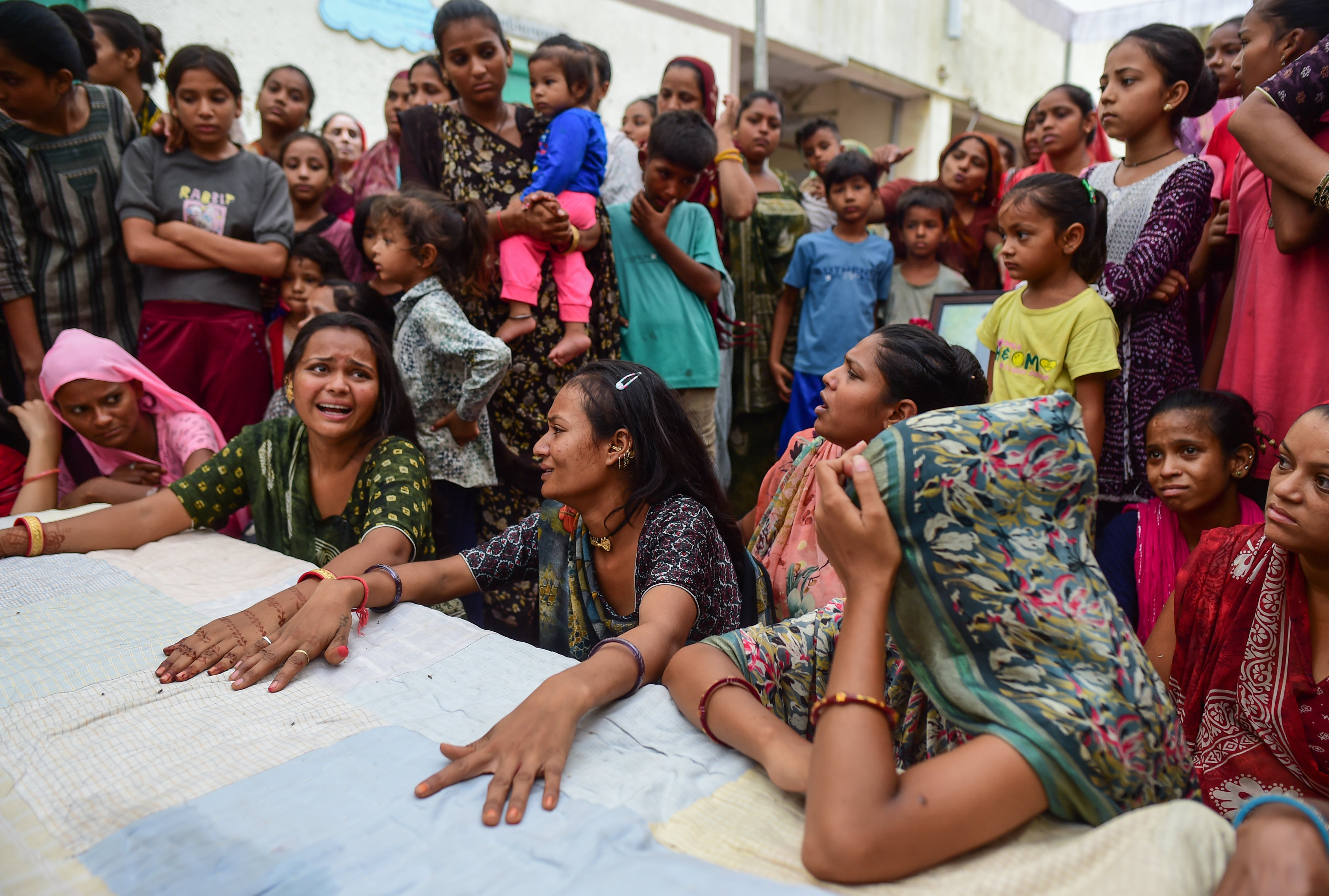 Relatives and neighbours of Akash Patni mourn as they wait for his body to arrive in Ahmedabad, India, on 15 June 2025