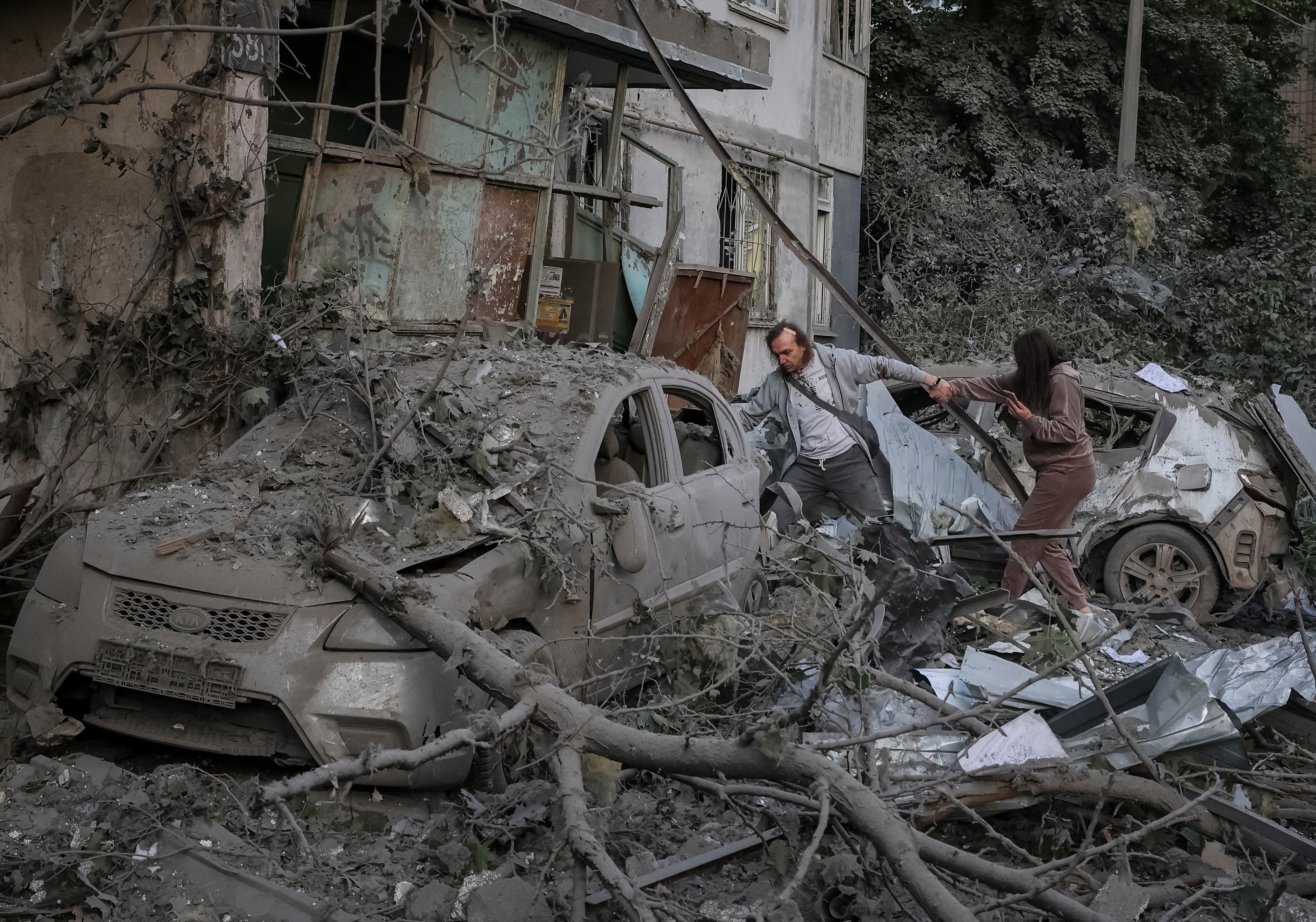 Residents near an apartment building damaged during a Russian drone and missile strike in Kyiv (Reuters)