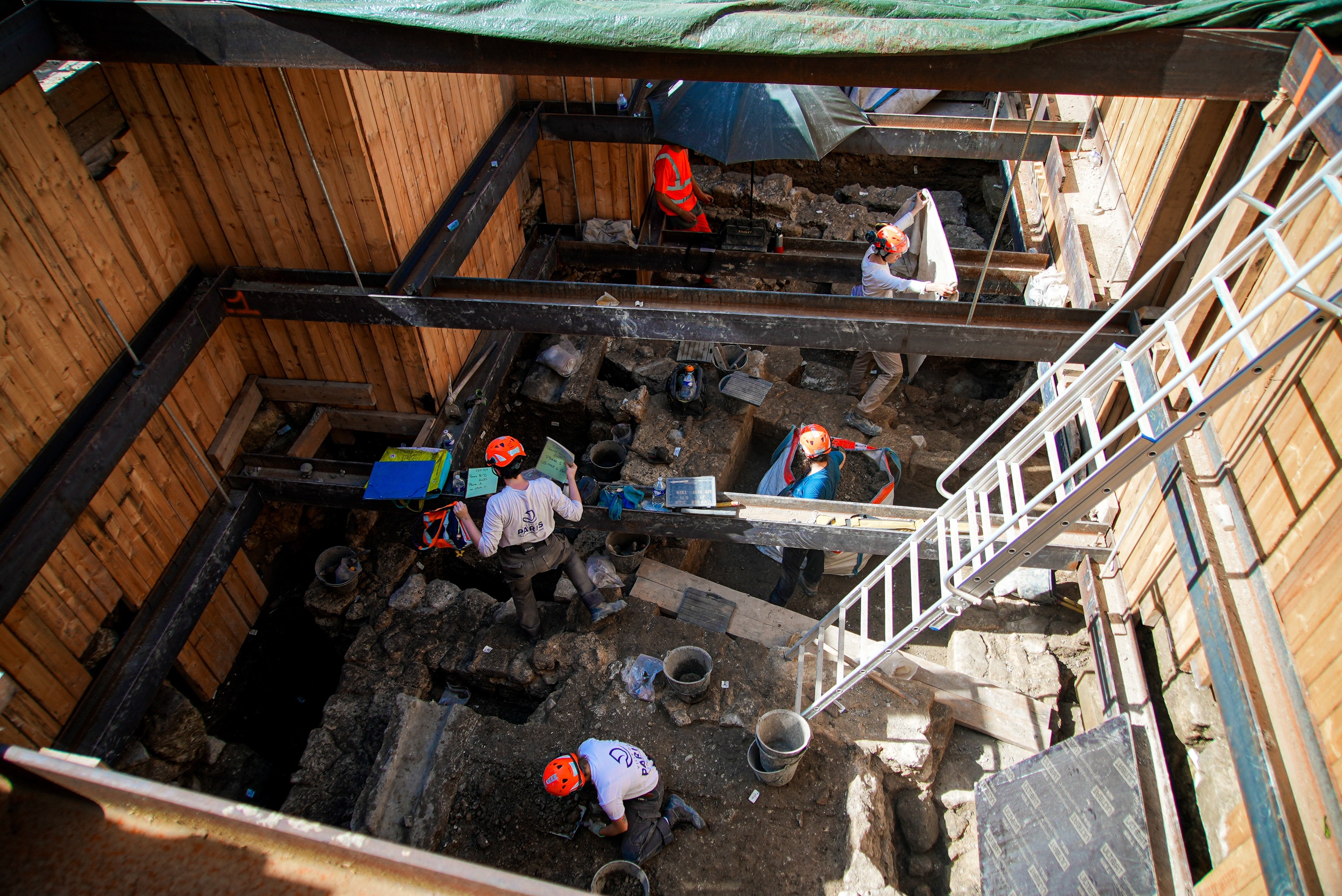 Archaeological workers wearing hard hats dig 4 meters (13 feet) underground during excavations outside Notre-Dame Cathedral in Paris