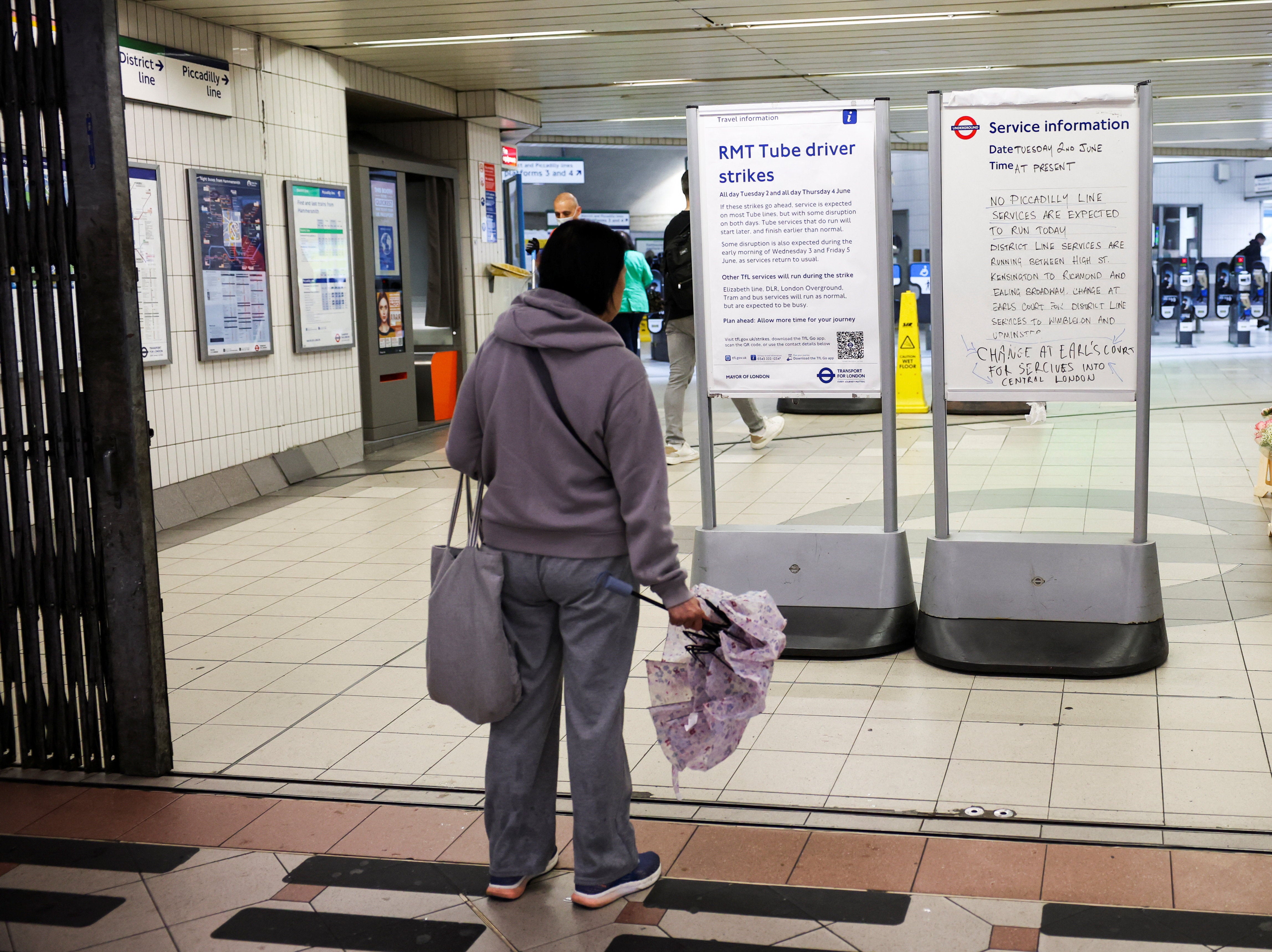 A member of the public reading the closure signs at a Tube entrance