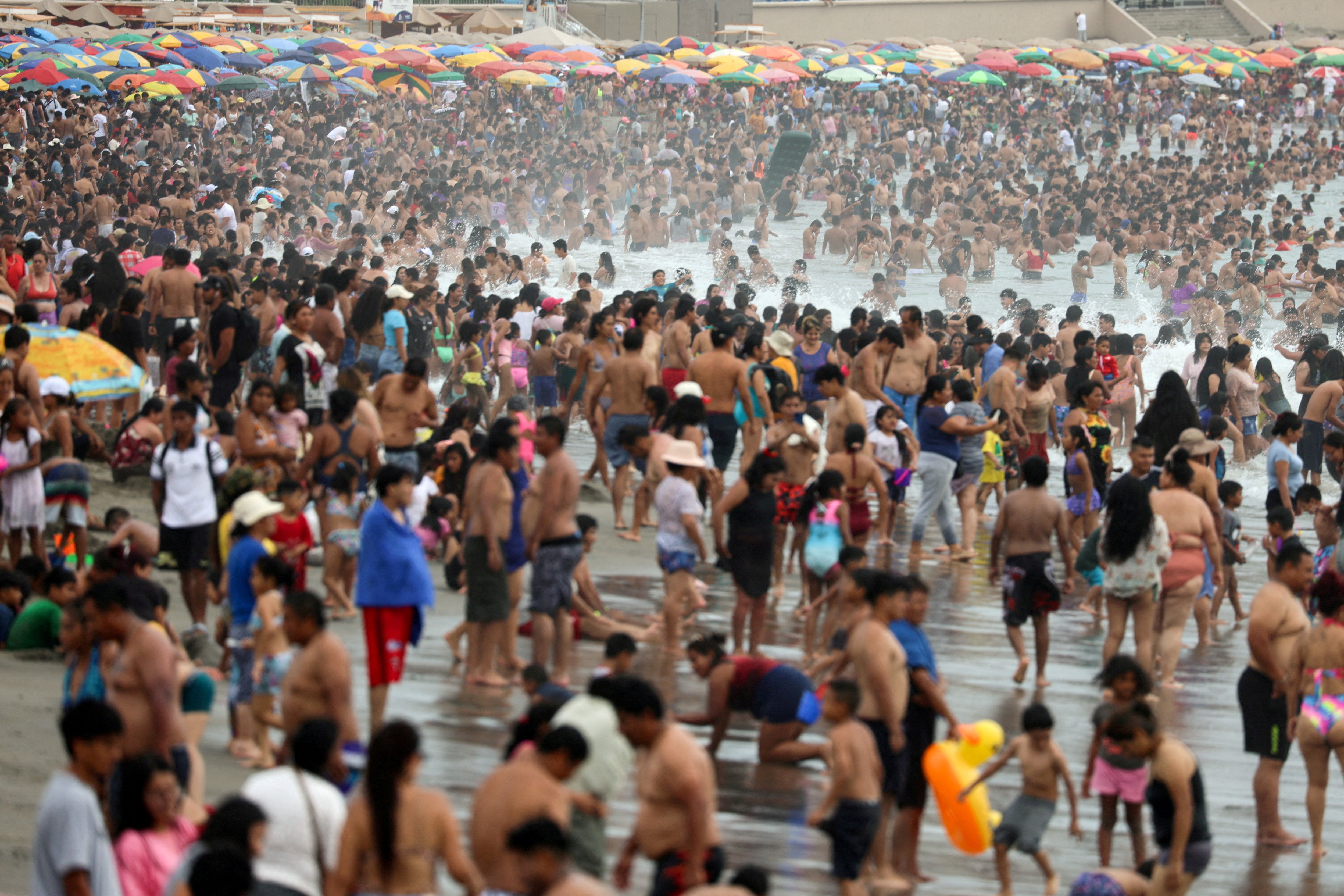 Bathers enjoy a summer day due to the high temperatures at Agua Dulce beach in the Chorrillos district, Lima, Peru (Reuters)