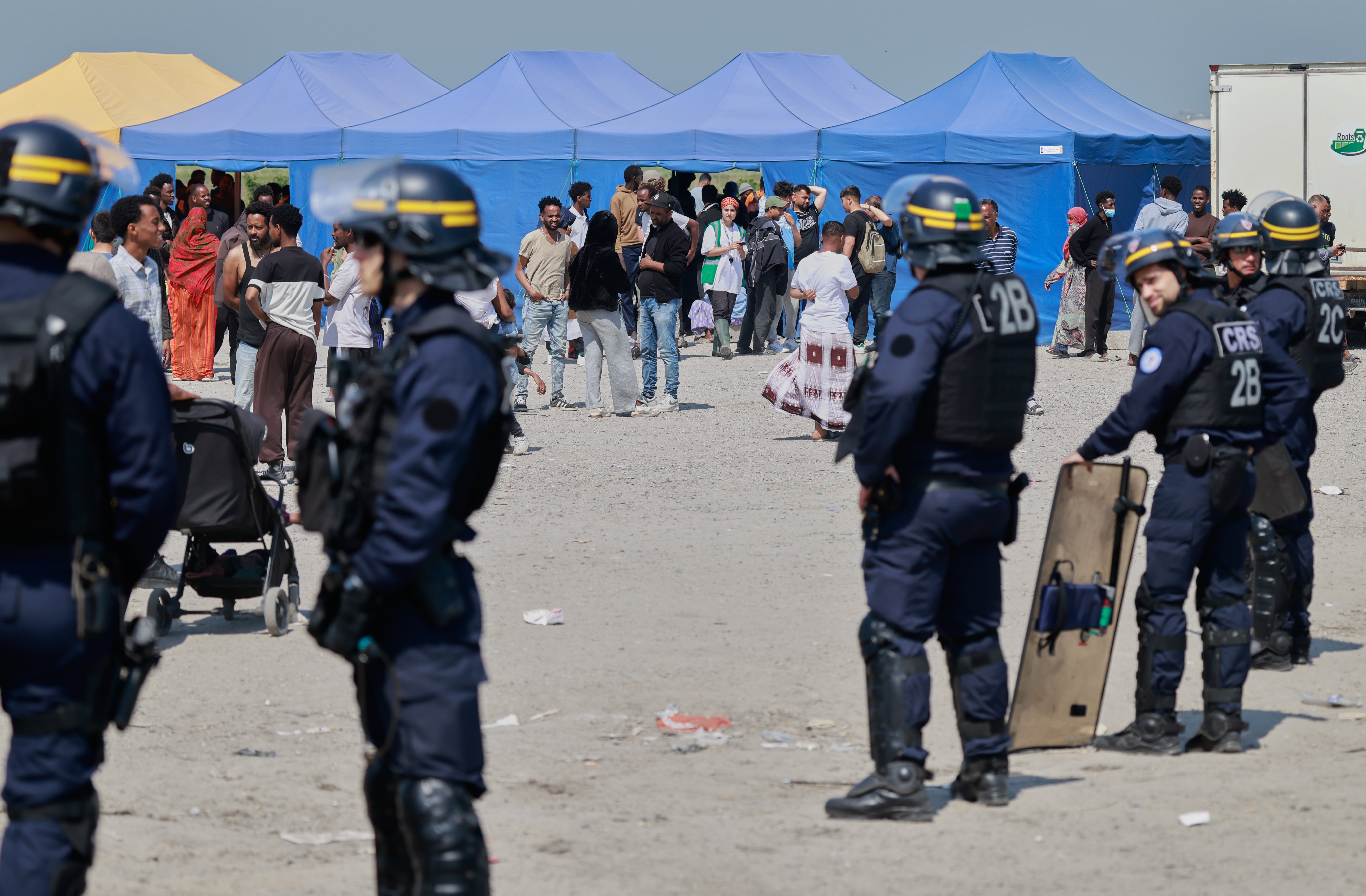 Police conduct a search operation at a makeshift camp of migrants who want to cross the English Channel to Britain near Dunkirk, northern France, Wednesday, May 27, 2026. (AP Photo/Jean-Francois Badias)