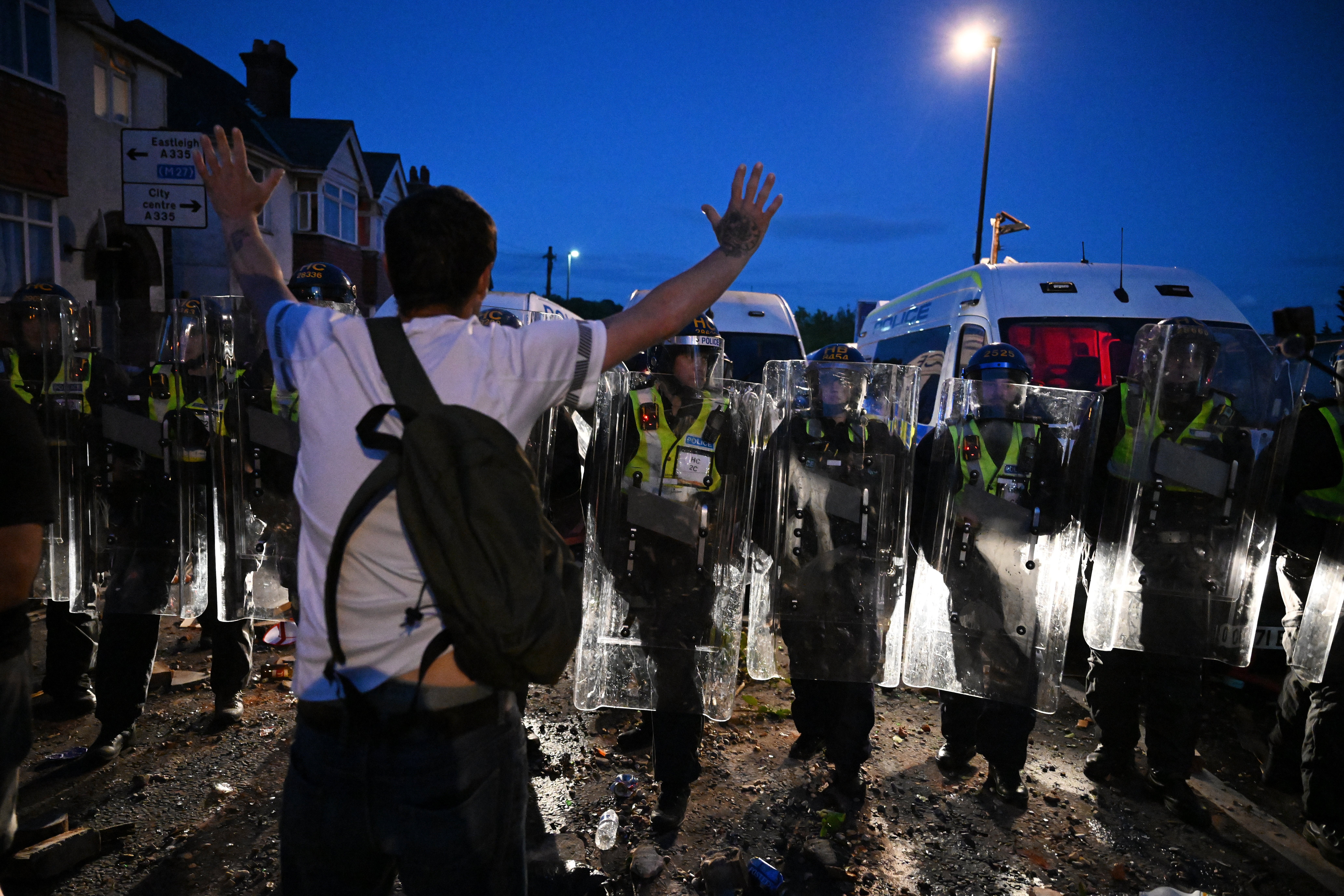 A protestor confronts riot police near the location where Henry Nowak died during a demonstration over the Police's handling of the incident