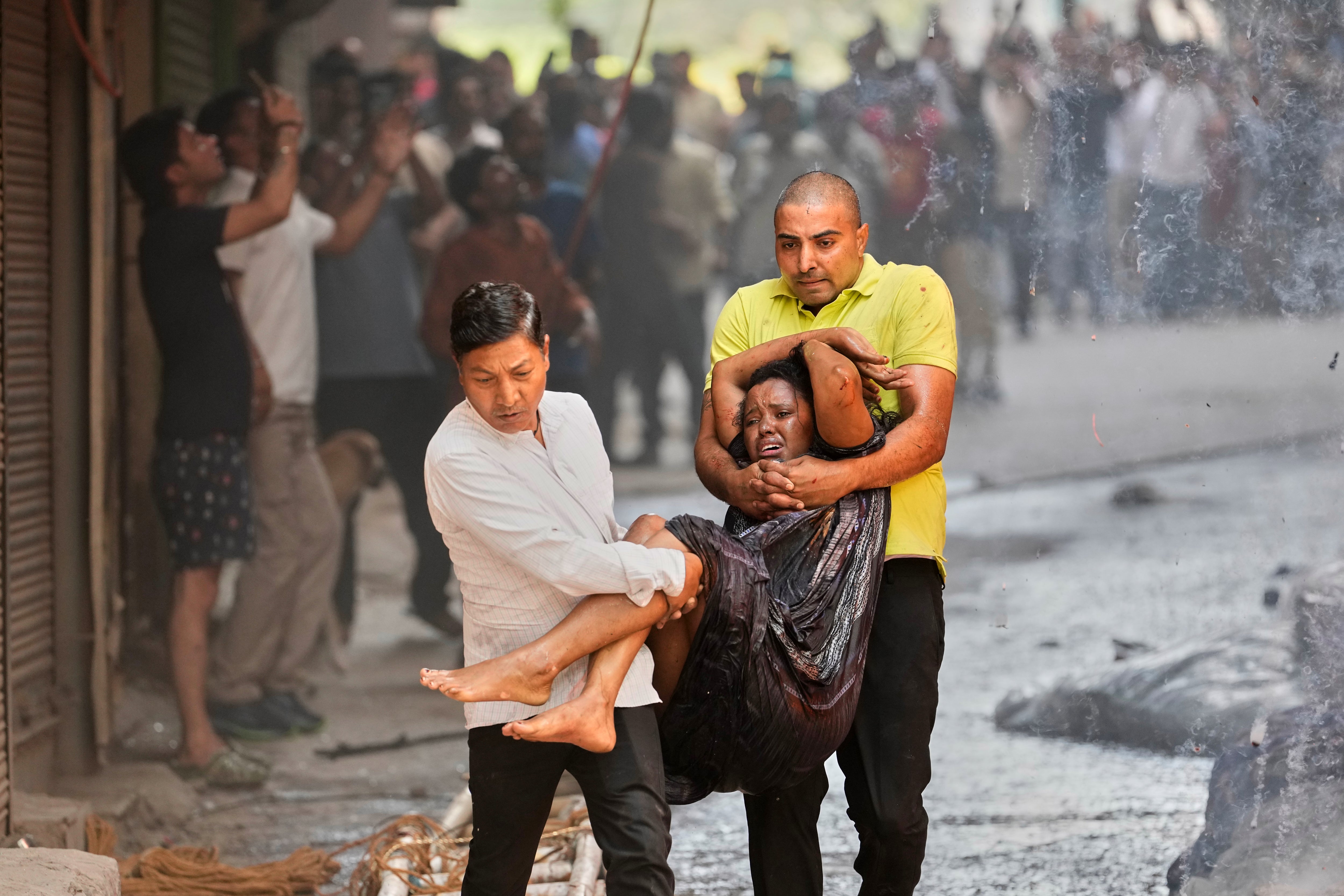 A woman is rescued from the burning building in New Delhi (AP)