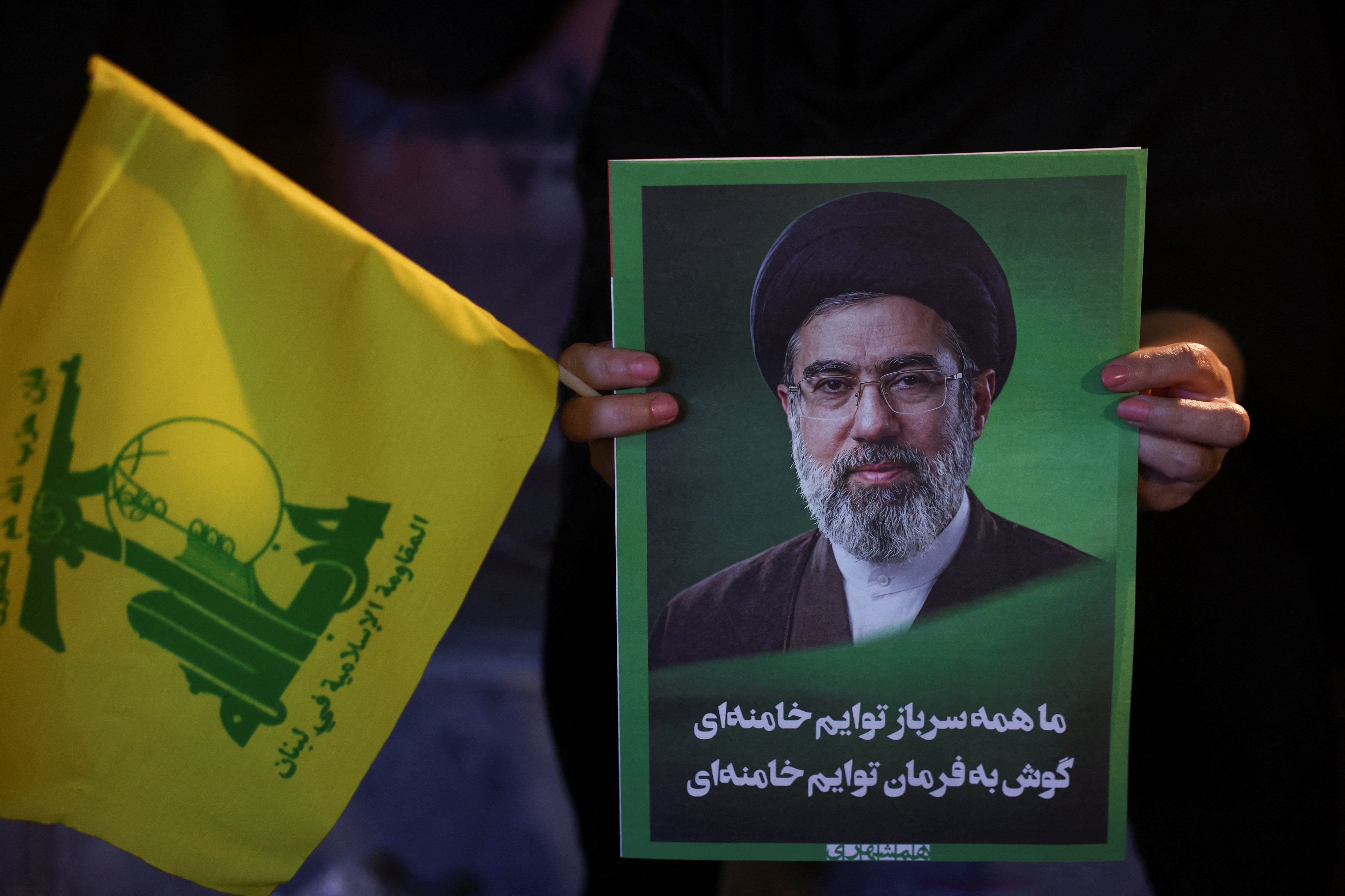 A woman holds an image of Iran's Supreme Leader, Mojtaba Khamenei, and a Hezbollah flag during a rally in Tehran, Iran, June 1, 2026. (Reuters)