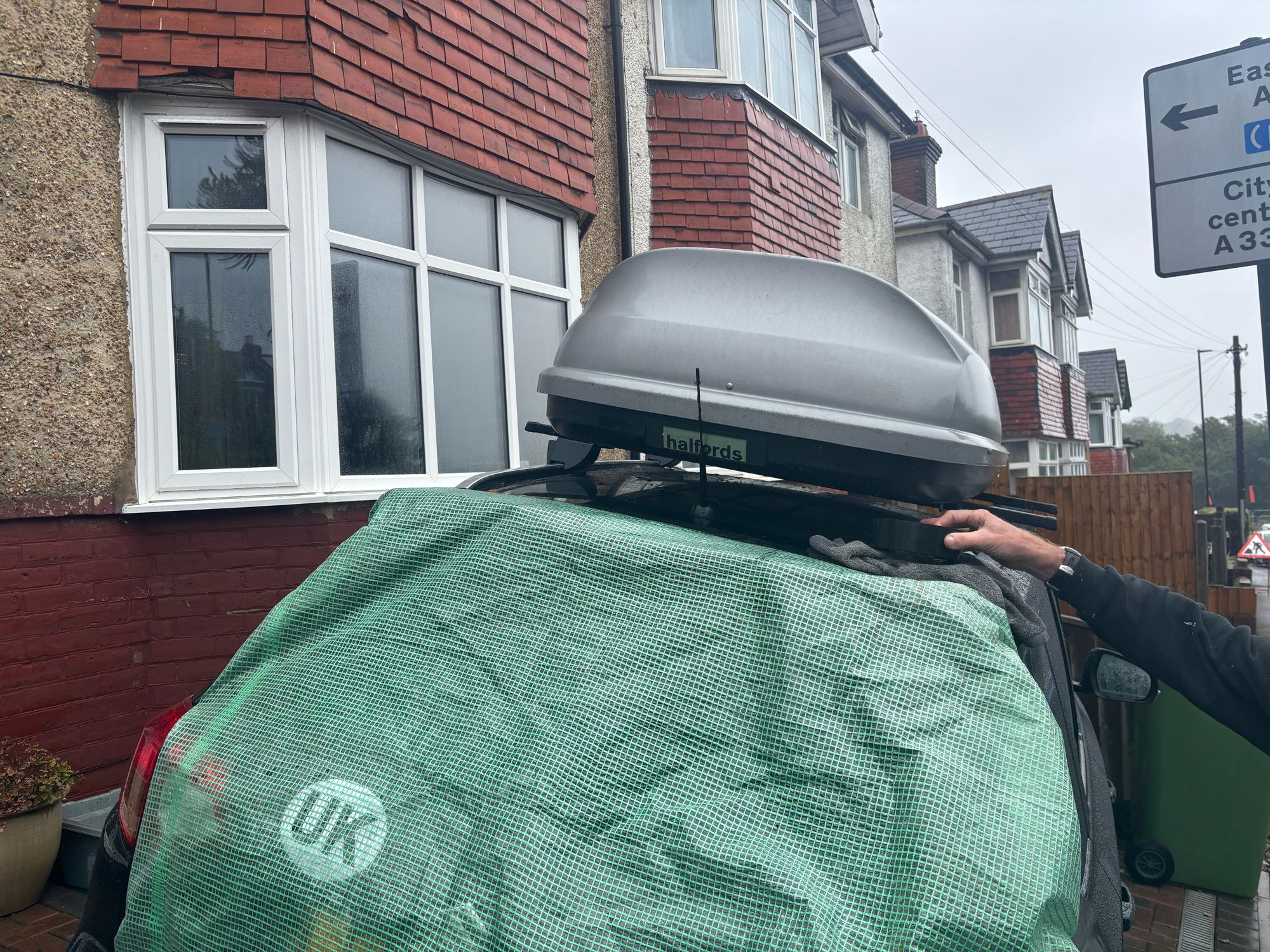 Sophie Martin, 38, was fixing plastic sheets across the rear windows of both of her cars parked outside her home after bricks were put through them last night (Dan Haygarth)