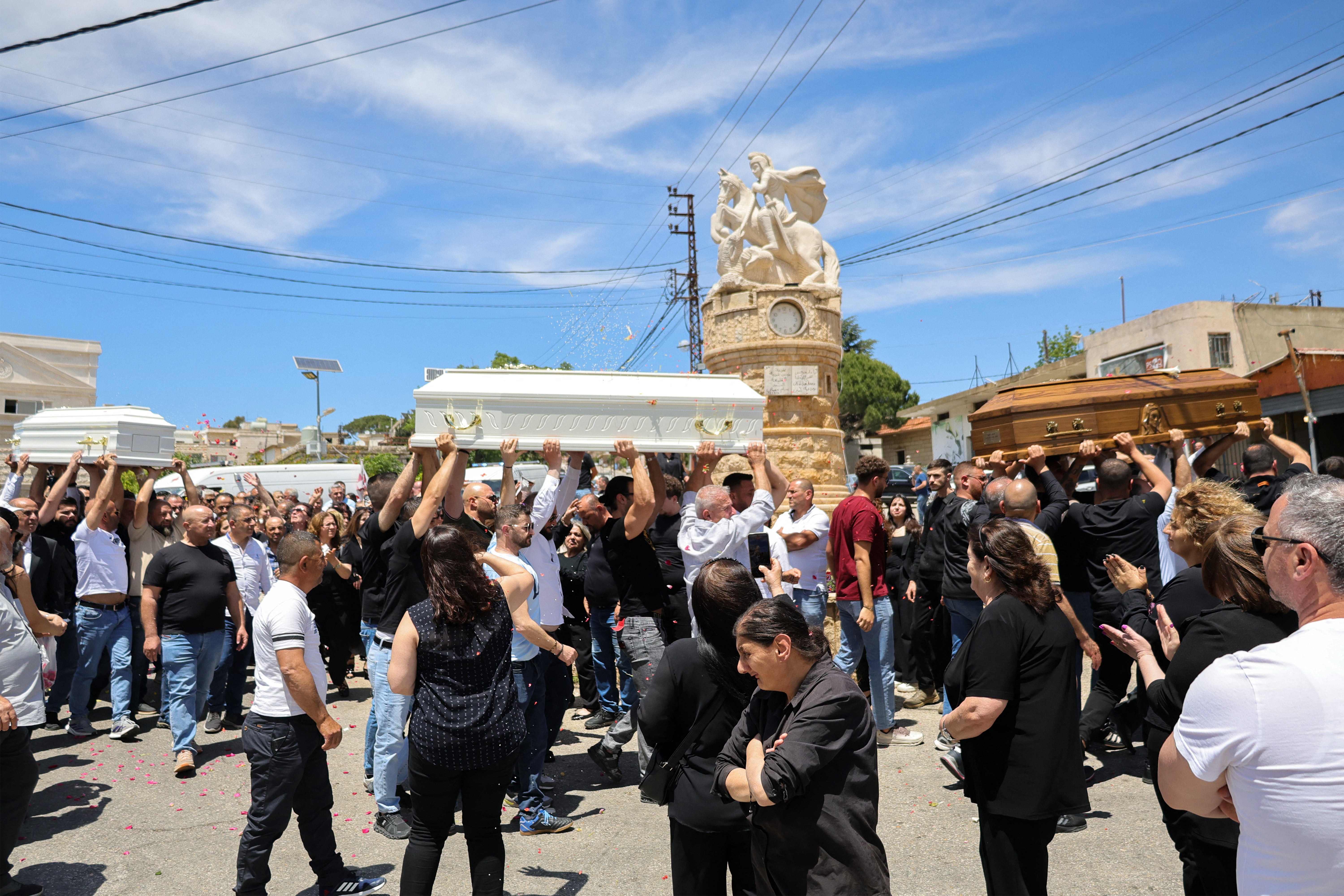 Relatives and friends of a man who was killed along with his son and daughter in an Israeli strike that targeted their car earlier this week in southern Lebanon attend their funeral in the christian border village of Qlayaa (AFP/Getty)