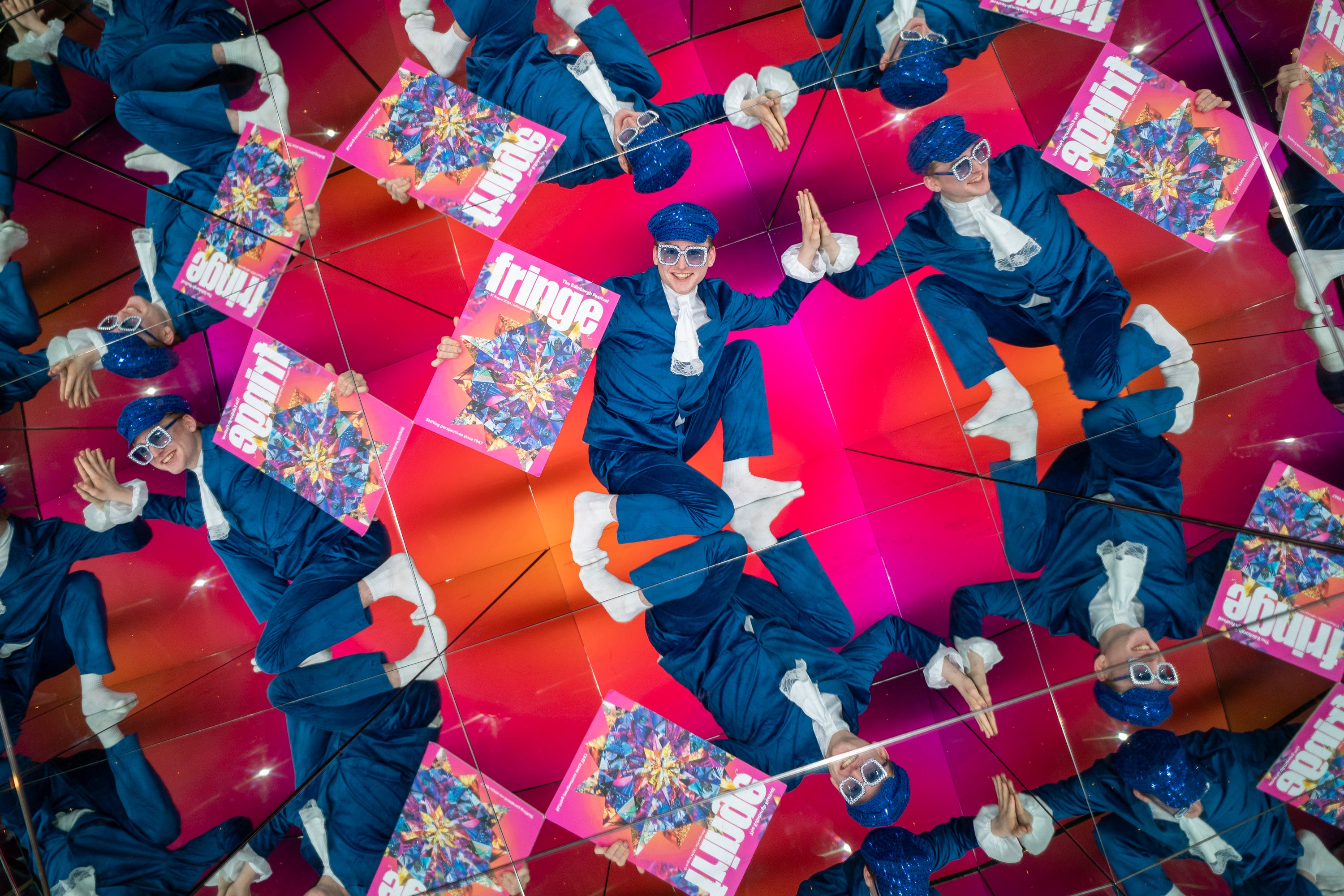 Performer Fintan McCarney poses with an oversized cut-out of the Edinburgh Fringe festival programme within Camera Obscura's Giant Kaleidoscope in Edinburgh