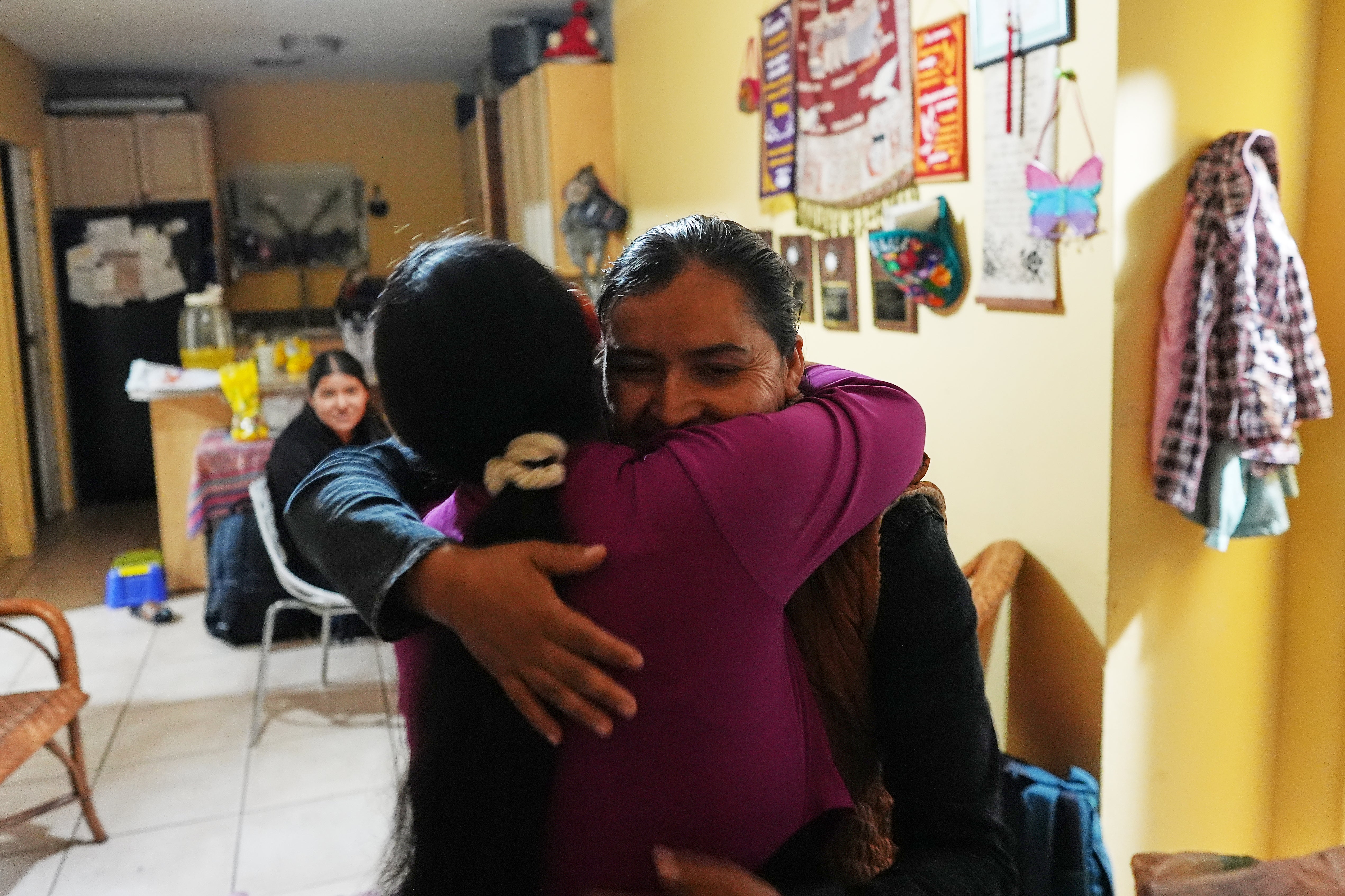 Alva Lopez, right, embraces a relative as she and her children return to the home they all shared in West Palm Beach, Fla., nearly one year after being separated by the Trump administration