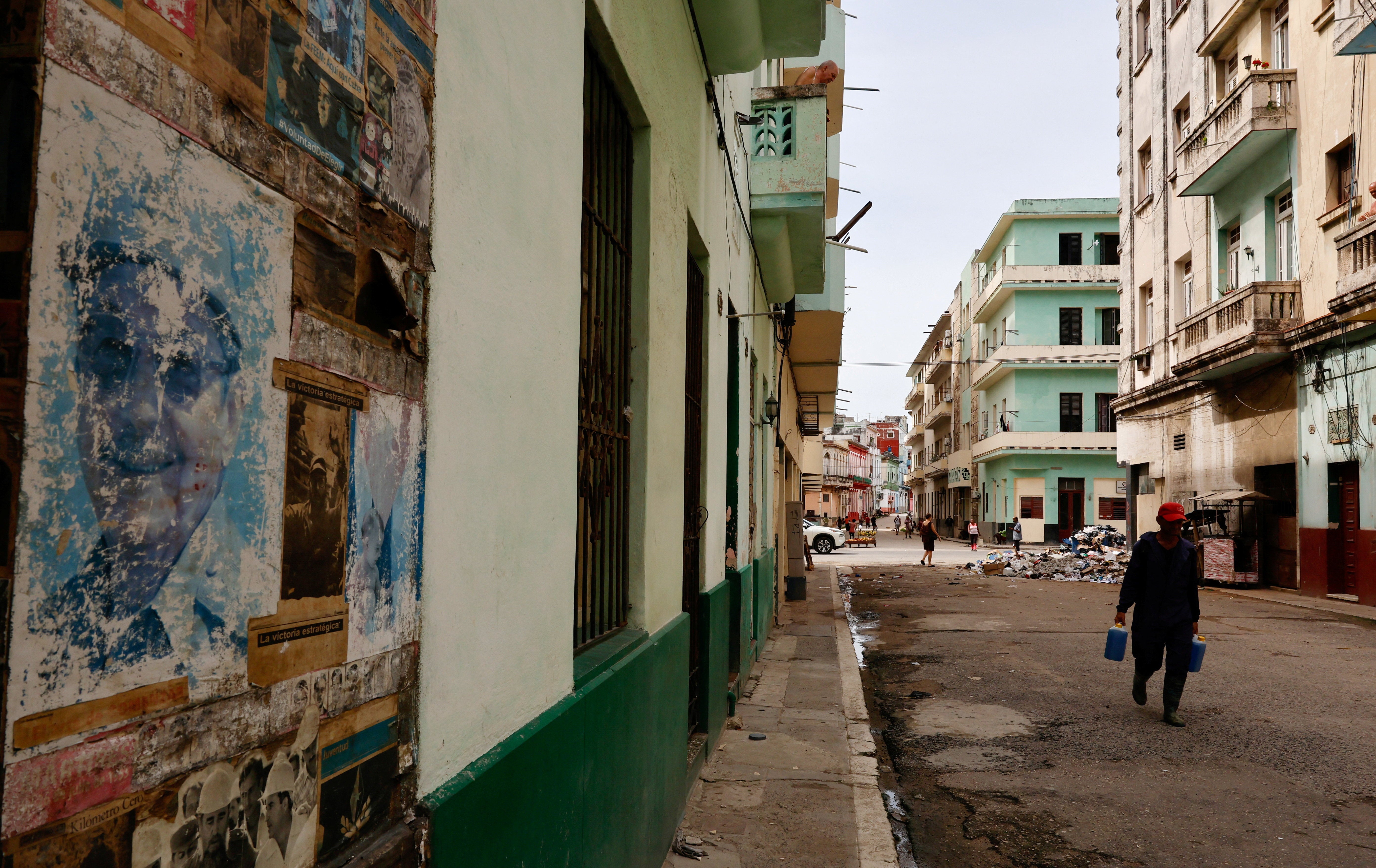 A man walks on a street and near a photo of Cuba's former President Raul Castro as the country marks Castro's 95th birthday after U.S. authorities charged him with murder in connection with the downing of civilian airplanes in 1996 and amid sanctions and a fuel blockade by the administration of U.S. President Donald Trump, in Havana, Cuba, June 3, 2026. REUTERS/Norlys Perez