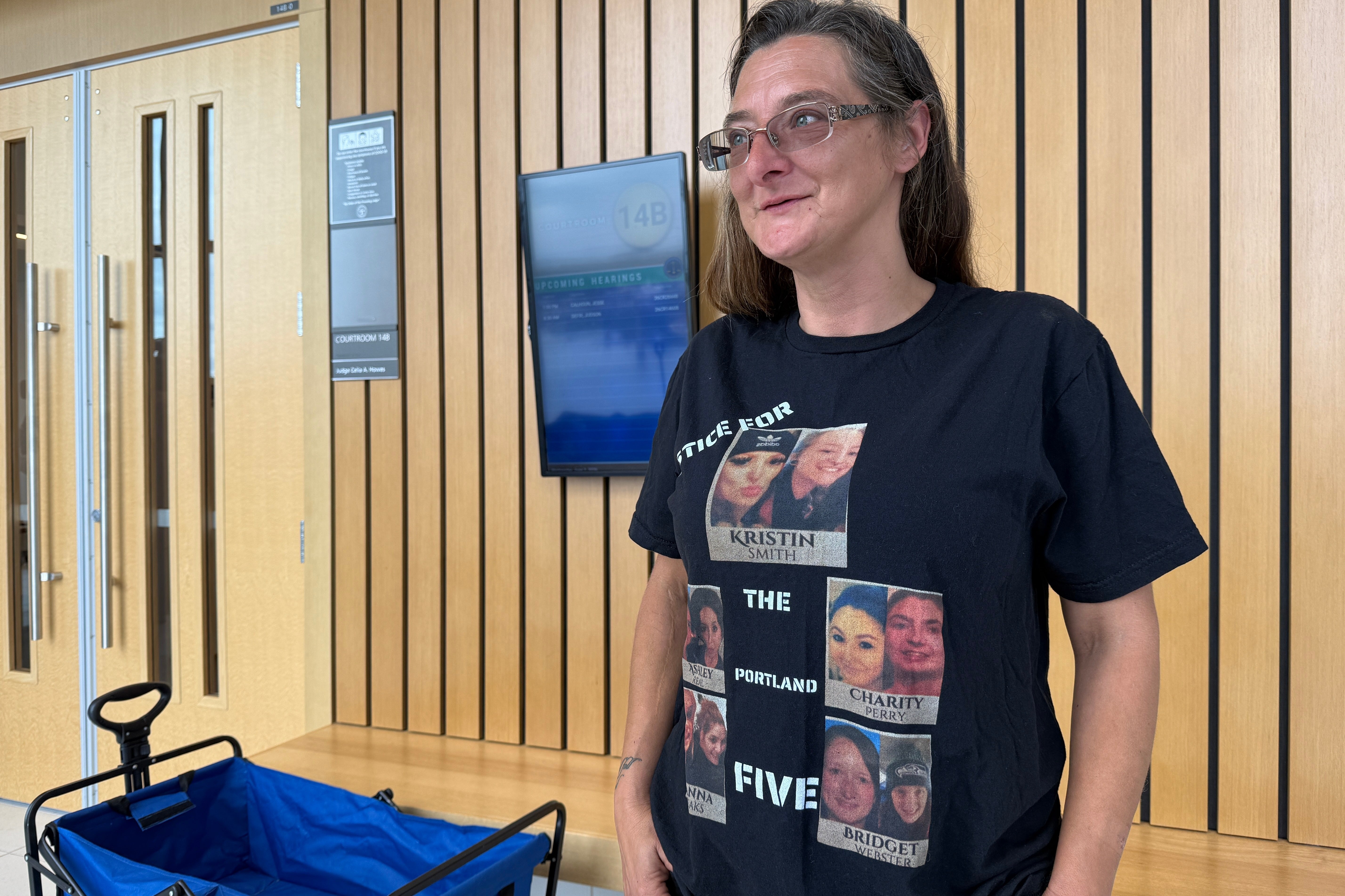 Diana Allen wears a shirt showing five women, including her daughter, Charity Perry, whom Jesse Calhoun is accused of murdering (AP)