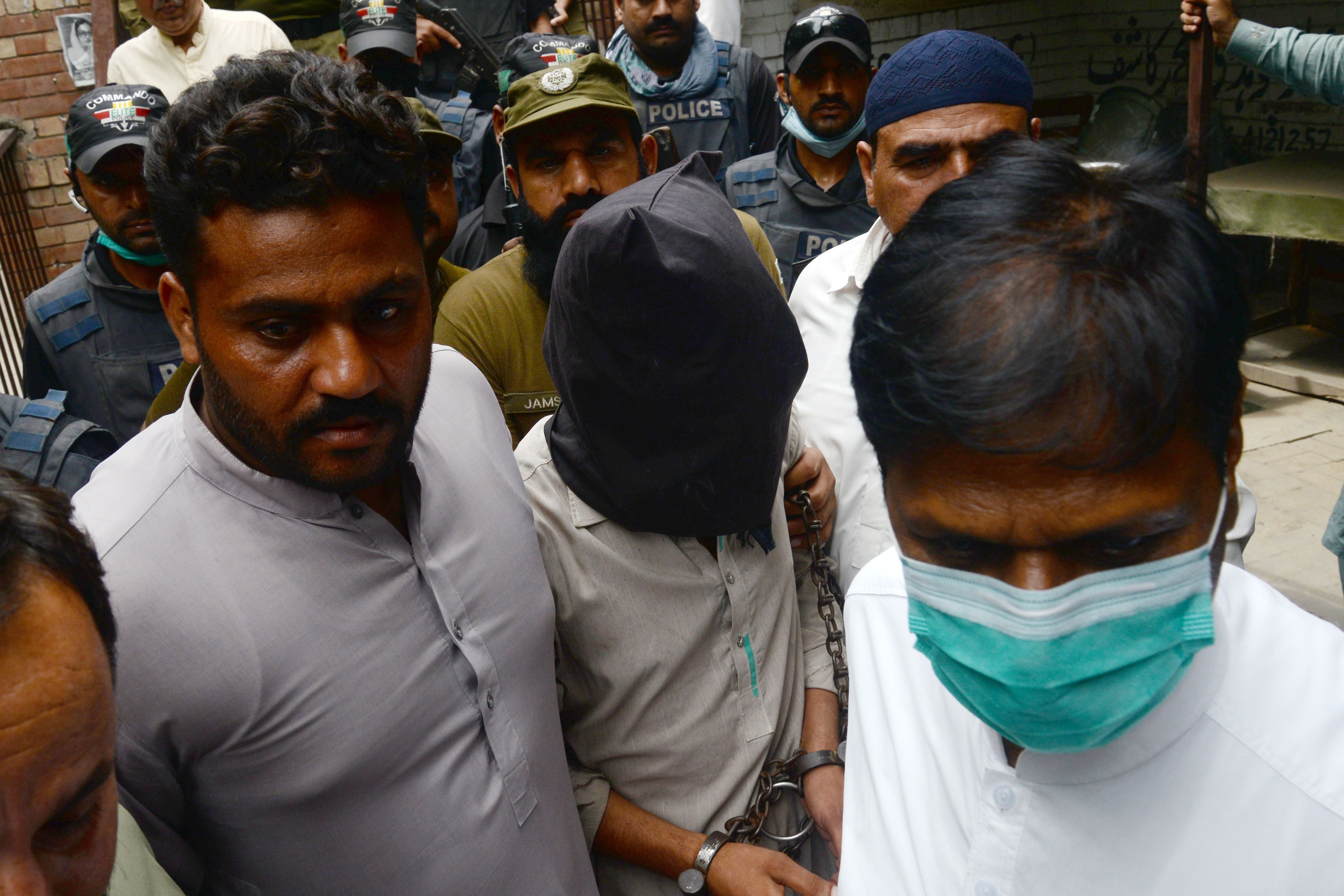 Policemen escort Shafqat Ali, one of two suspects in the gang-rape case, as they leave from a local court in Lahore