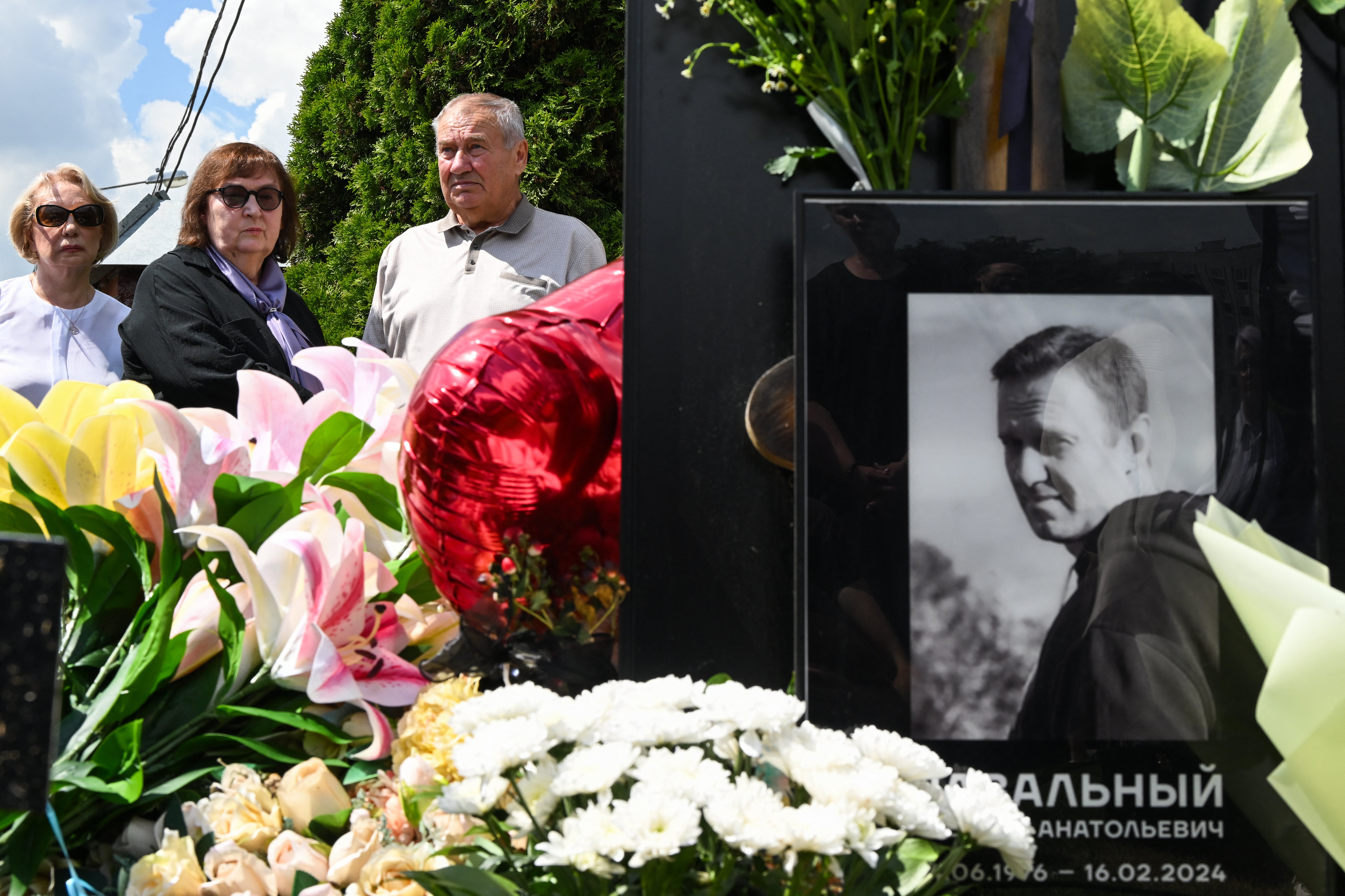 Parents of the late Russian opposition leader Alexei Navalny Lyudmila (C) and Anatoly and his mother-in-law Alla Abrosimova (L) visit his grave to mark his 50th birthday at the Borisovo cemetery in Moscow on June 4 (AFP/Getty)