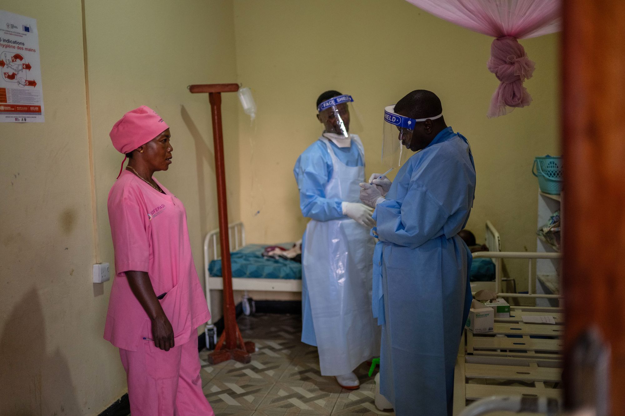 Manza Pantience, left, a midwife at Karibuni wa Mama, supervises health workers who collect patients' samples for Ebola testing at Sofepadi Hospital in Bunia, Congo