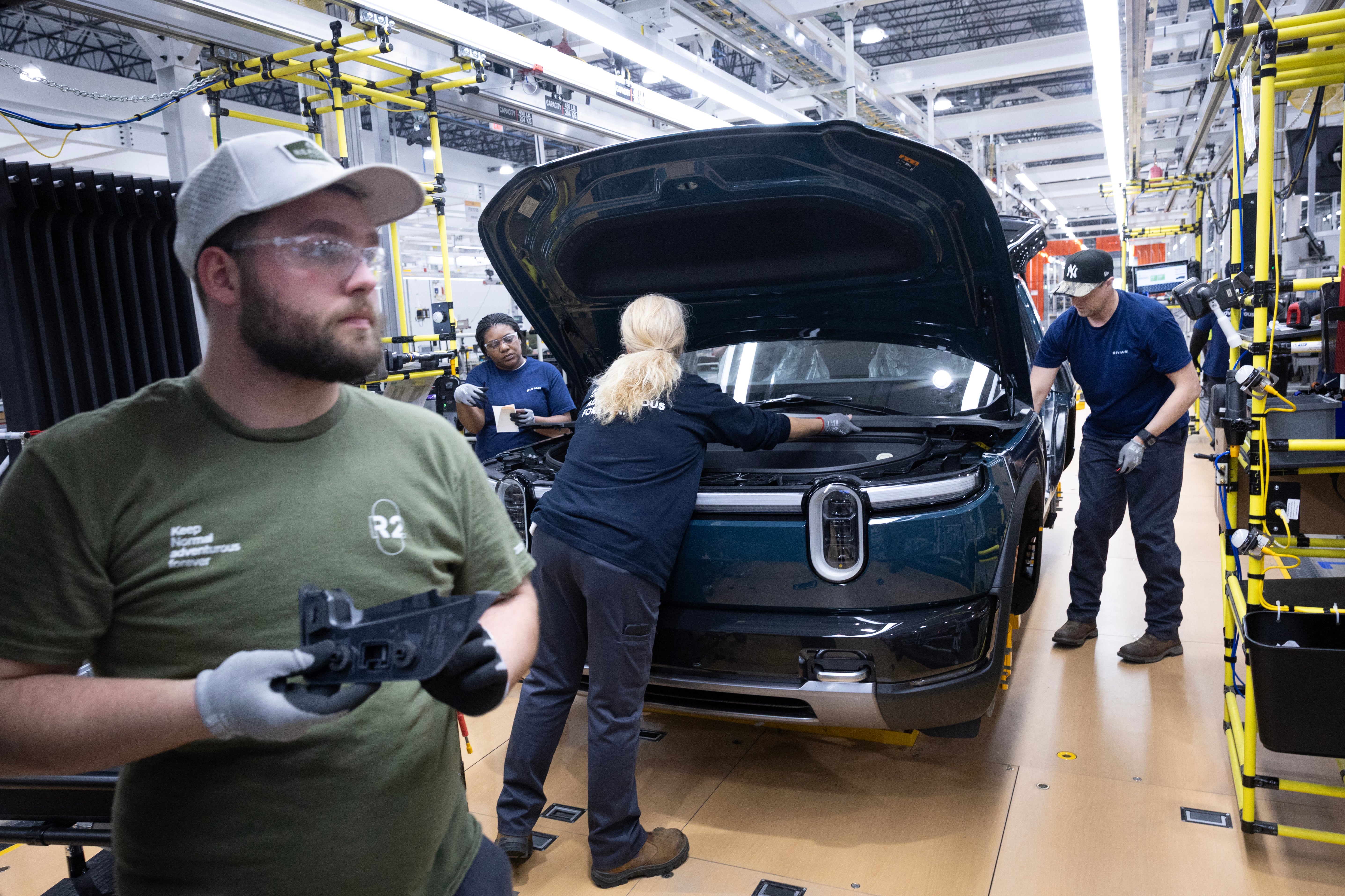 Since Trump took office, the US lost 77,000 manufacturing jobs. Pictured: Workers build Rivian R2 SUVs at the manufacturer's assembly plant on May 19, 2026 in Normal, Illinois (Getty)