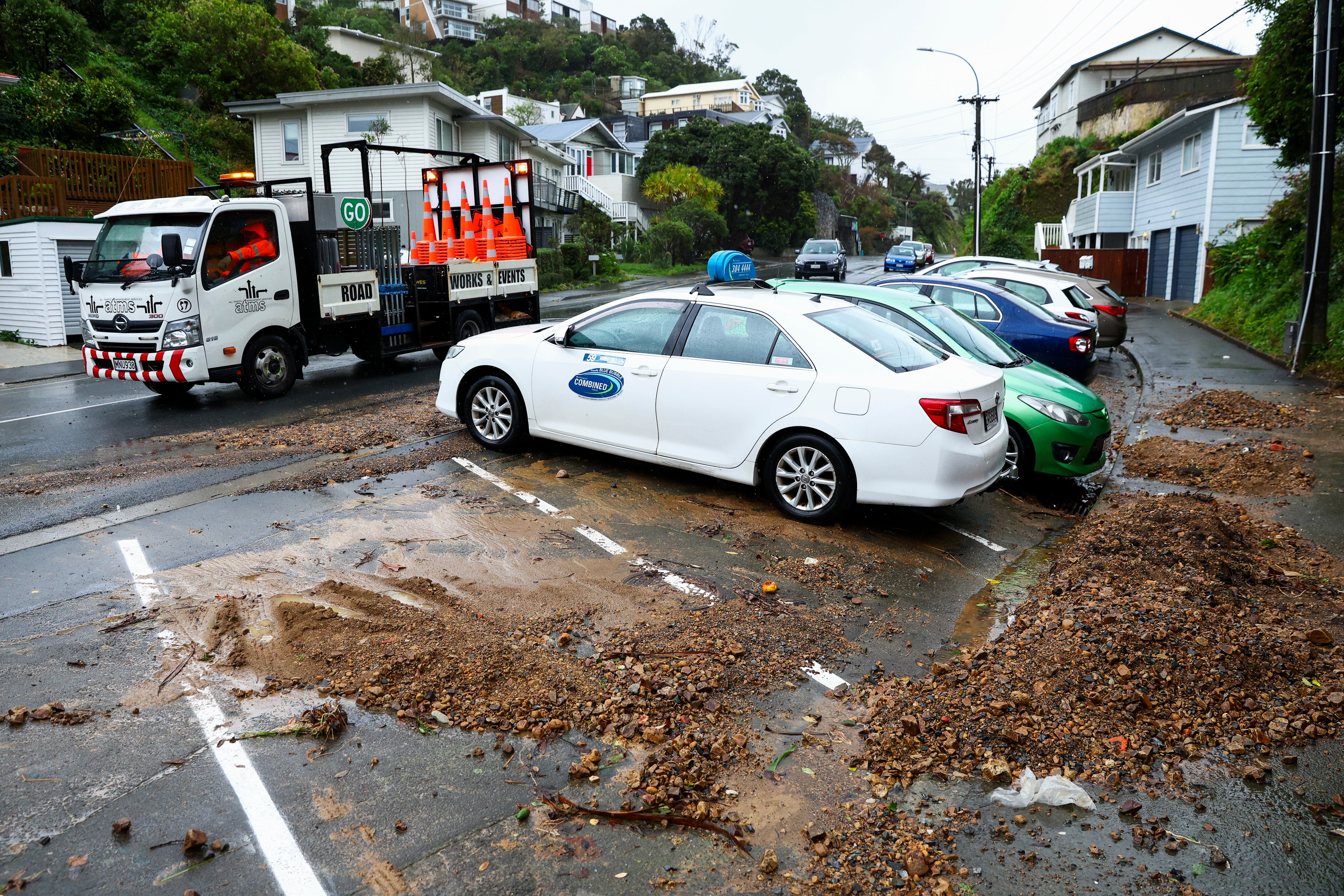File: Road workers drive past a slip in the suburb of Brooklyn during a bout of severe weather in April