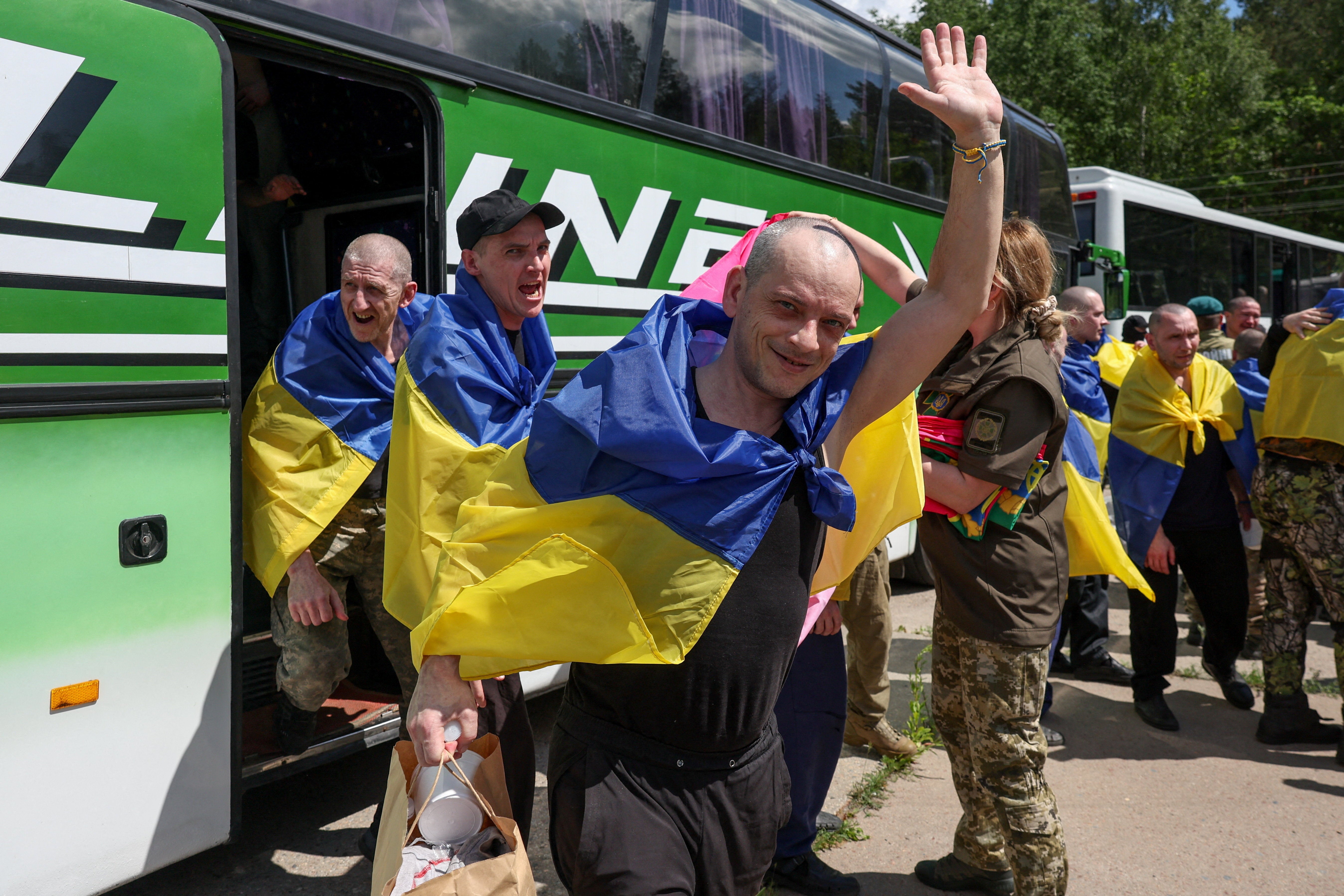 Ukrainian prisoners of war (POWs) exit a bus after a swap, amid Russia's attack on Ukraine, at an undisclosed location in Ukraine (Reuters)