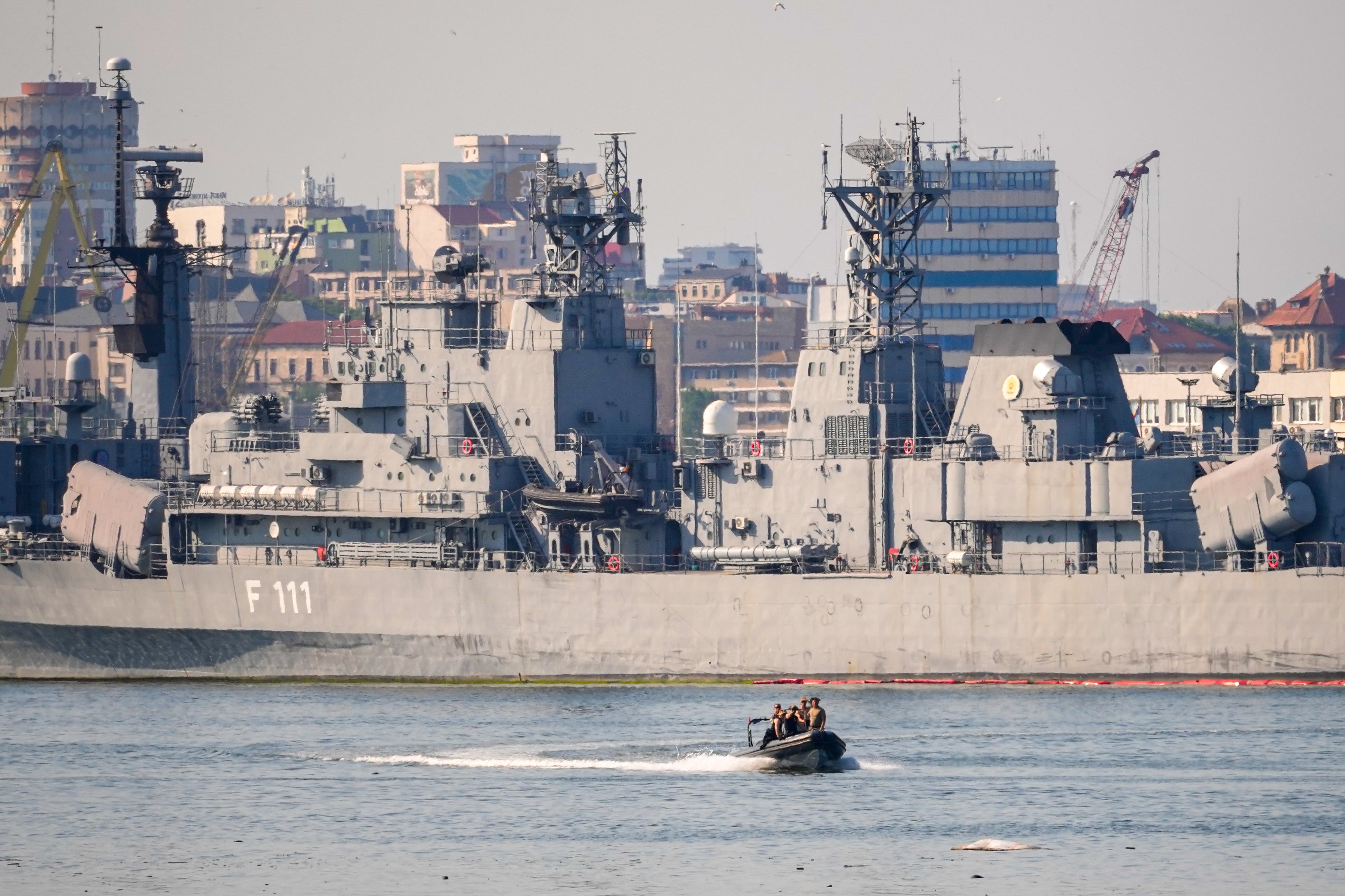 A small military patrol boat sails past the Romanian frigate Marasesti docked in the military port of Constanta