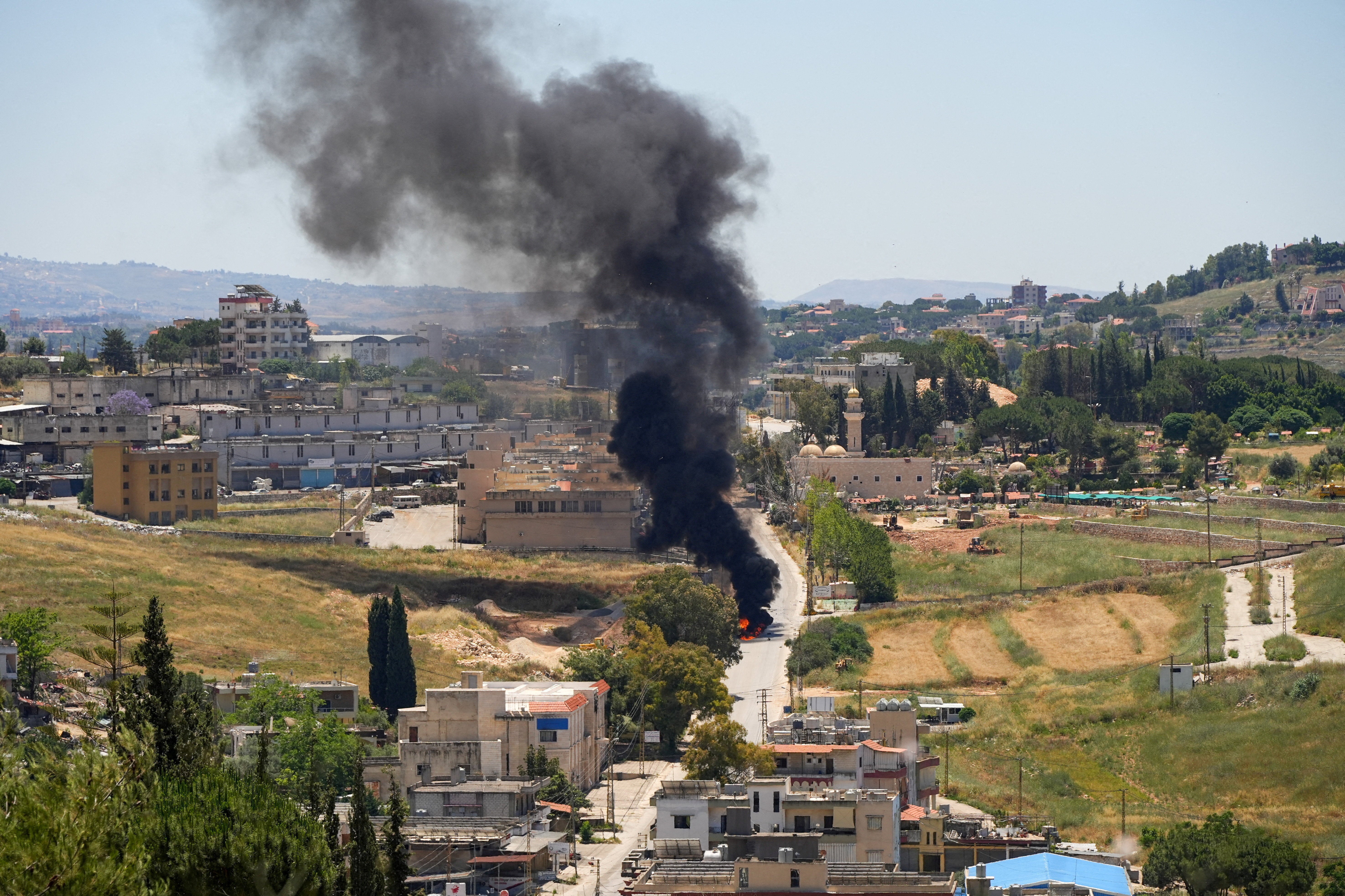 Black smoke billows at a strike scene following an Israeli strike on a car as seen from Nabatieh, Lebanon