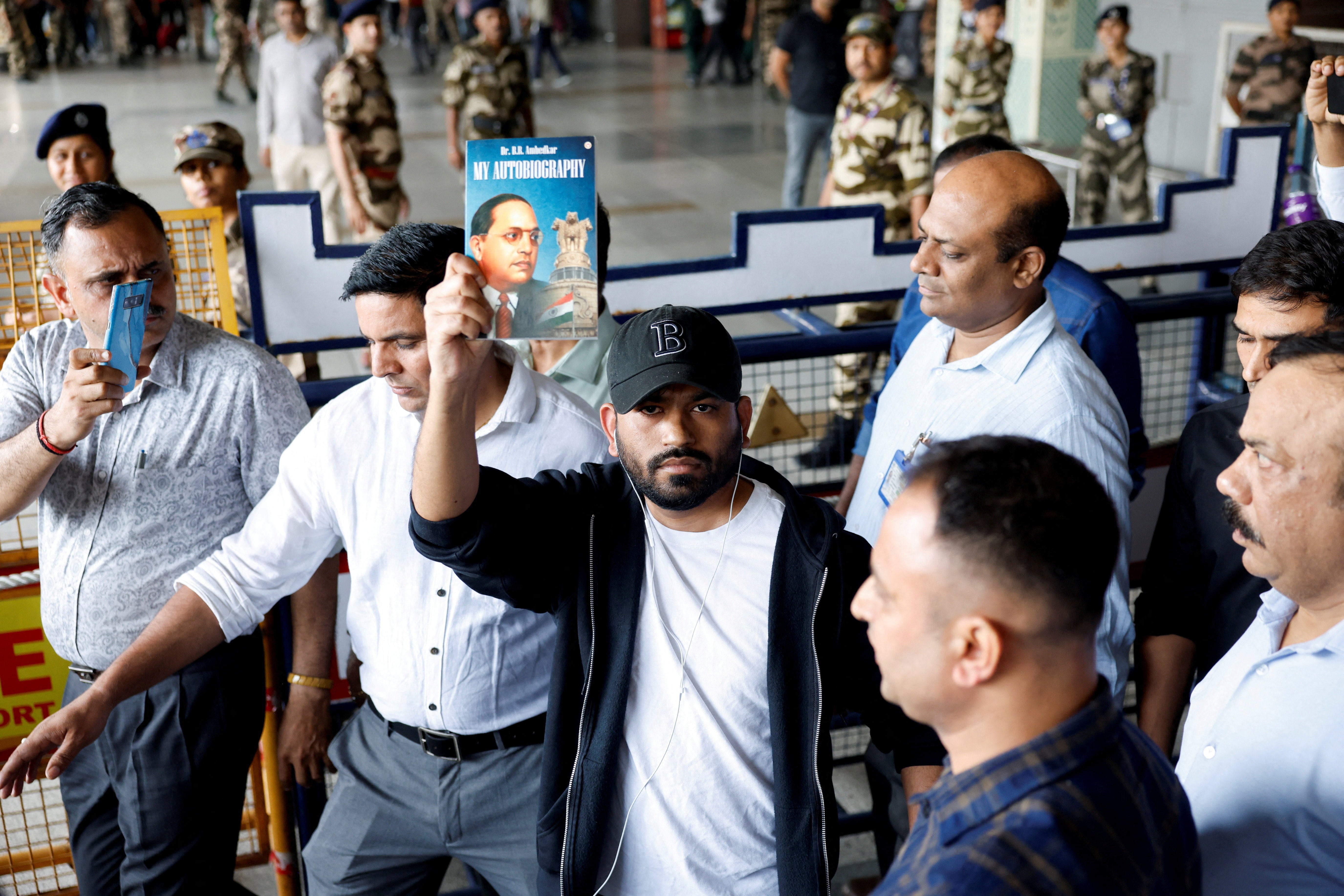 Abhijeet Dipke, head of the Cockroach Janta Party (CJP), holds a copy of 'My Autobiography' by Dr B R Ambedkar upon his arrival at Delhi airport from the US
