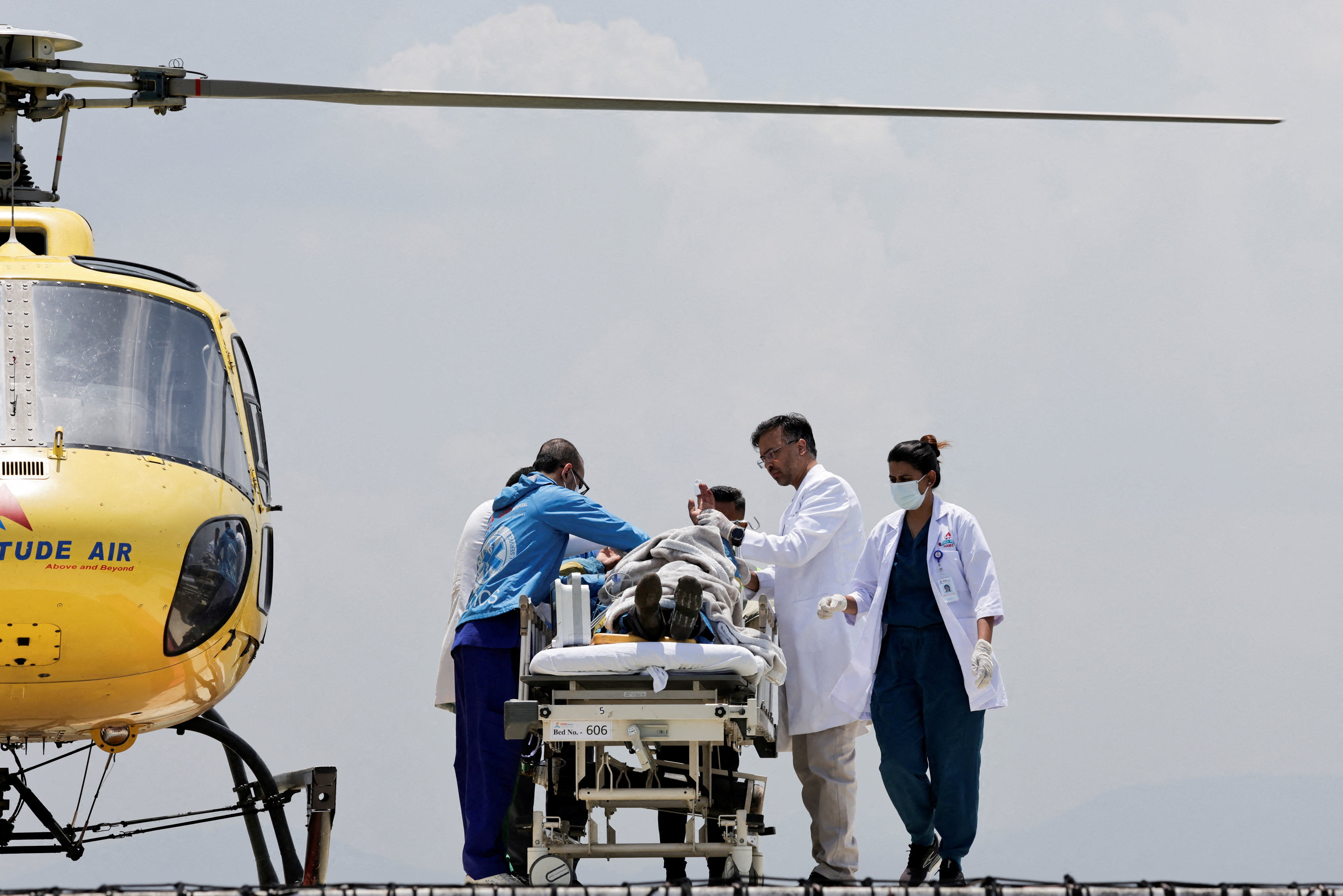 Paramedics work to transport Dawa Sherpa, who was missing for several days in the Everest region, from the helipad at HAMS Hospital in Kathmandu, Nepal, 4 June 2026