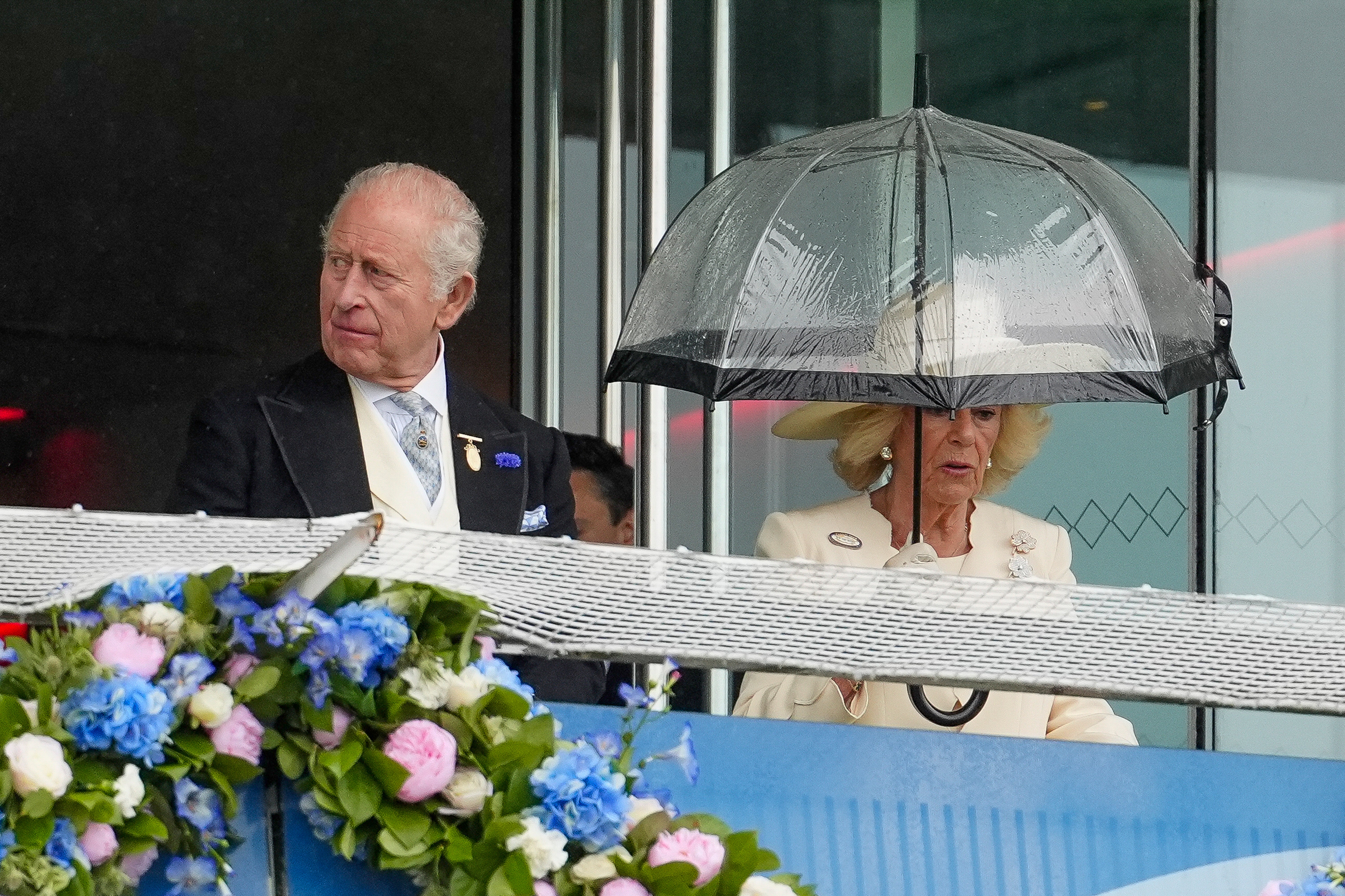 King Charles III and Queen Camilla on the balcony of The Queen Elizabeth II Stand during The Betfred Derby Day