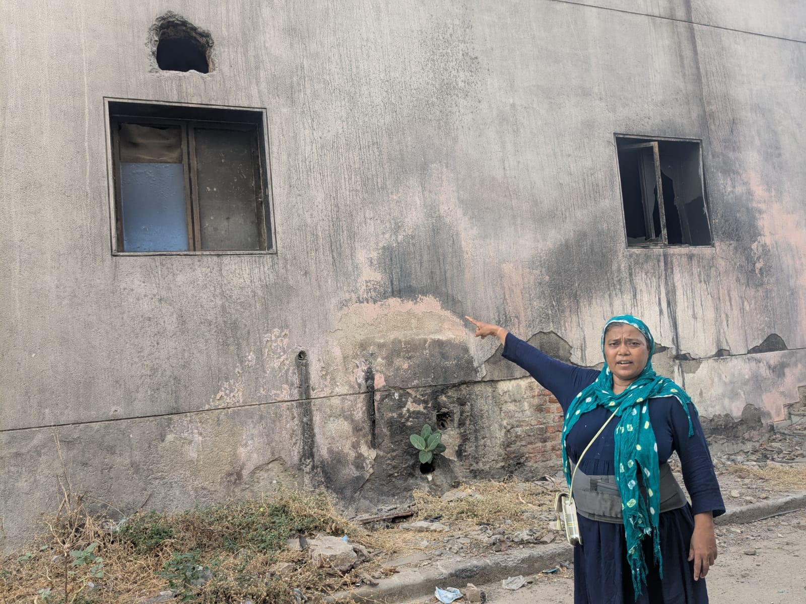 Gitaben Manubhai Patel, 56, showing the window from which she jumped after the crash to escape injuries