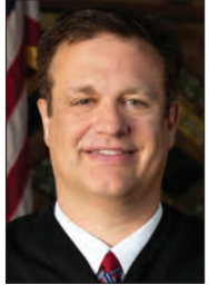 Judge Ryan Nelson is accused of knocking a man’s glasses off his head and stomping on them in a parking lot. he has pleaded not guilty to the charges