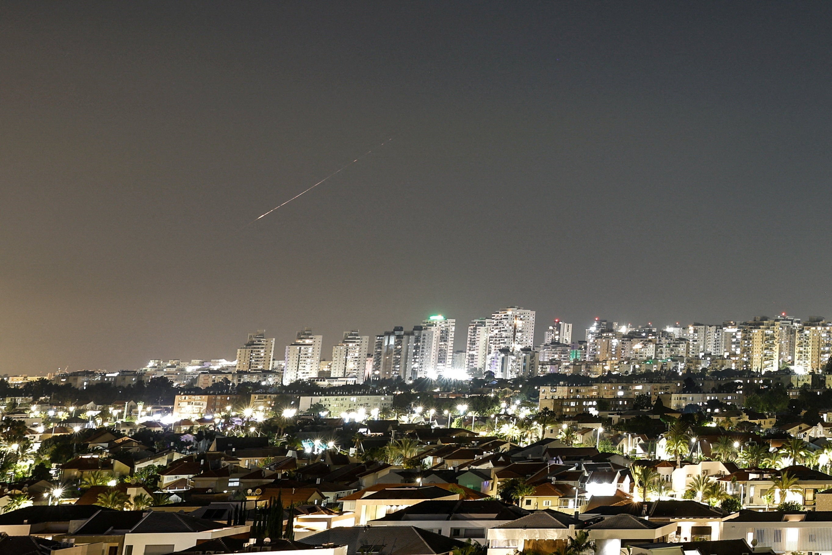 A streak of light illuminates the sky during a missile attack from Iran towards Israel as seen from Ashkelon, Israel, June 7 (Reuters)