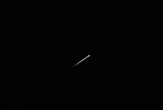 A streak of light illuminates the sky during a missile attack from Iran towards Israel, as seen from Jerusalem